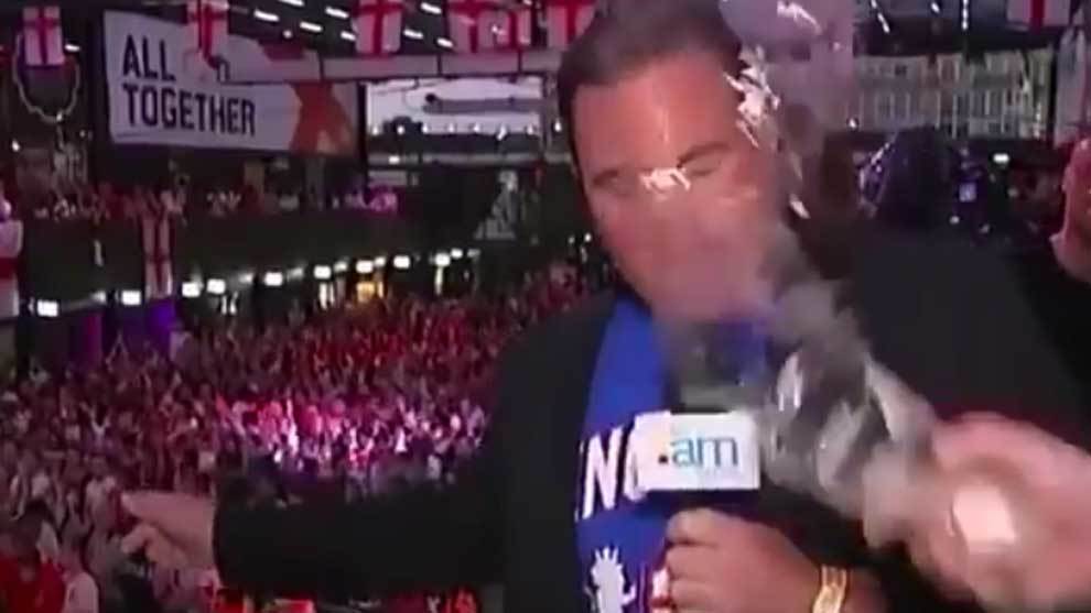 Un hooligan frustrado le lanza un vaso de cerveza a un reportero en directo