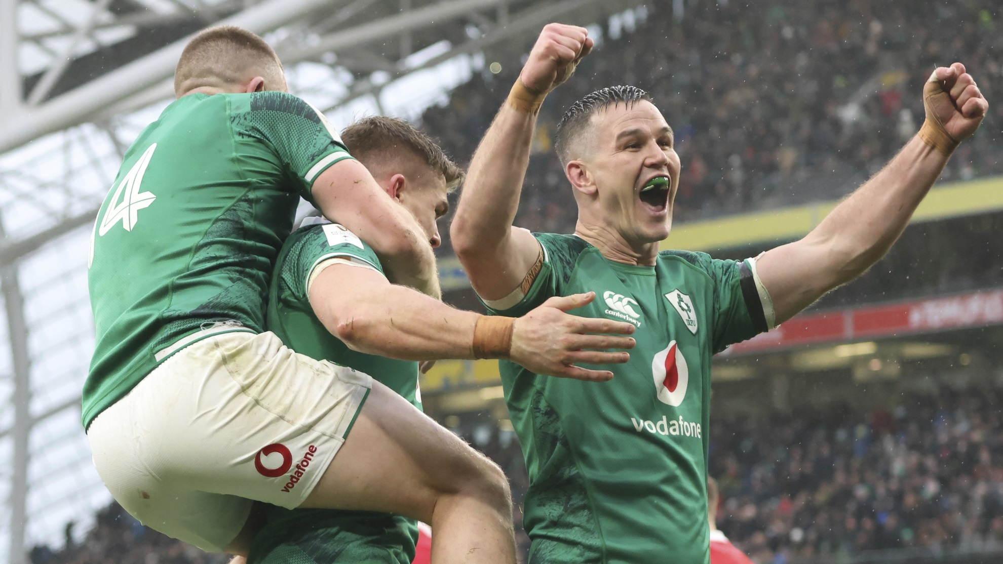 Jonathan Sexton celebrates with Andrew Conway and Garry Ringrose, after Ringrose scores a try.