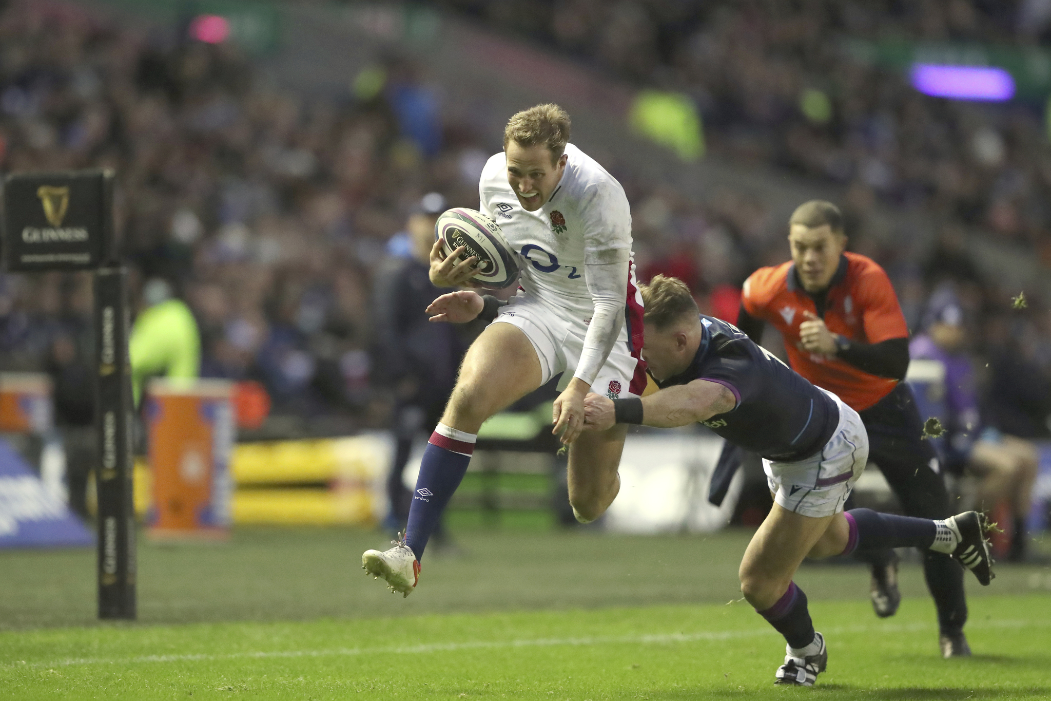 England's Max Malins, left, is tackled by Scotland's Stuart Hogg.