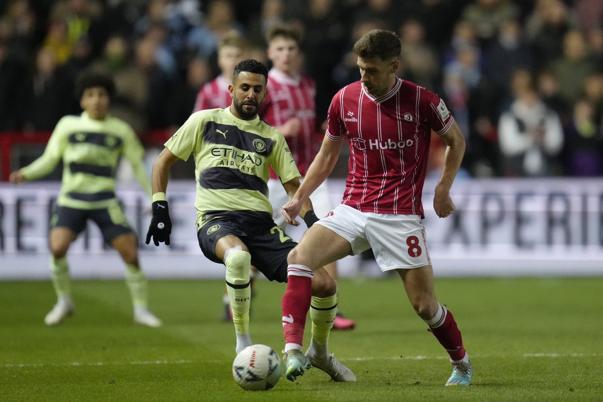 Bristol City's Joe Williams, right, challenges for the ball with Manchester City's Riyad Mahrez