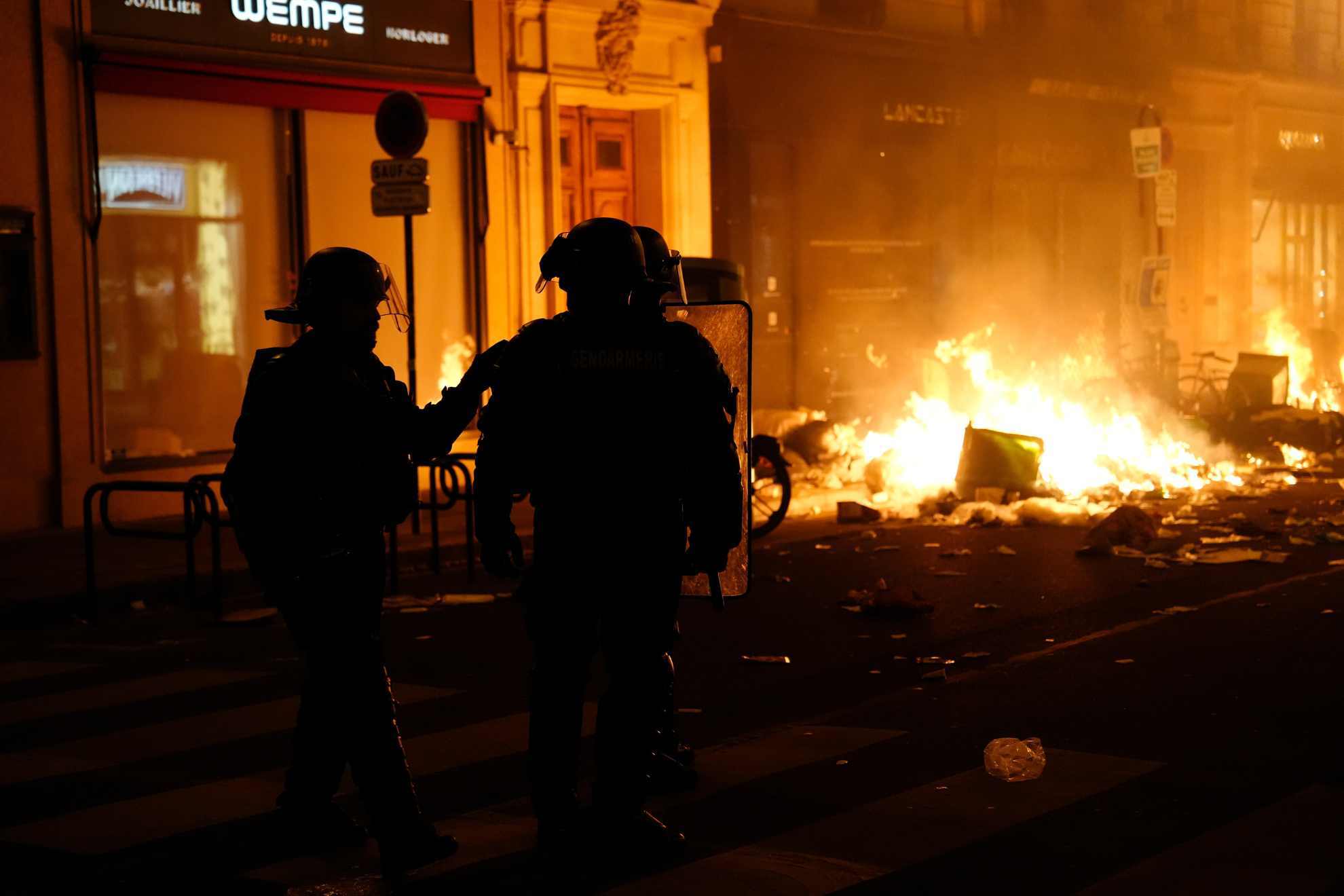Firefighters put out a fire near Concorde square after a demonstration in Paris, Thursday, March 16, 2023.
