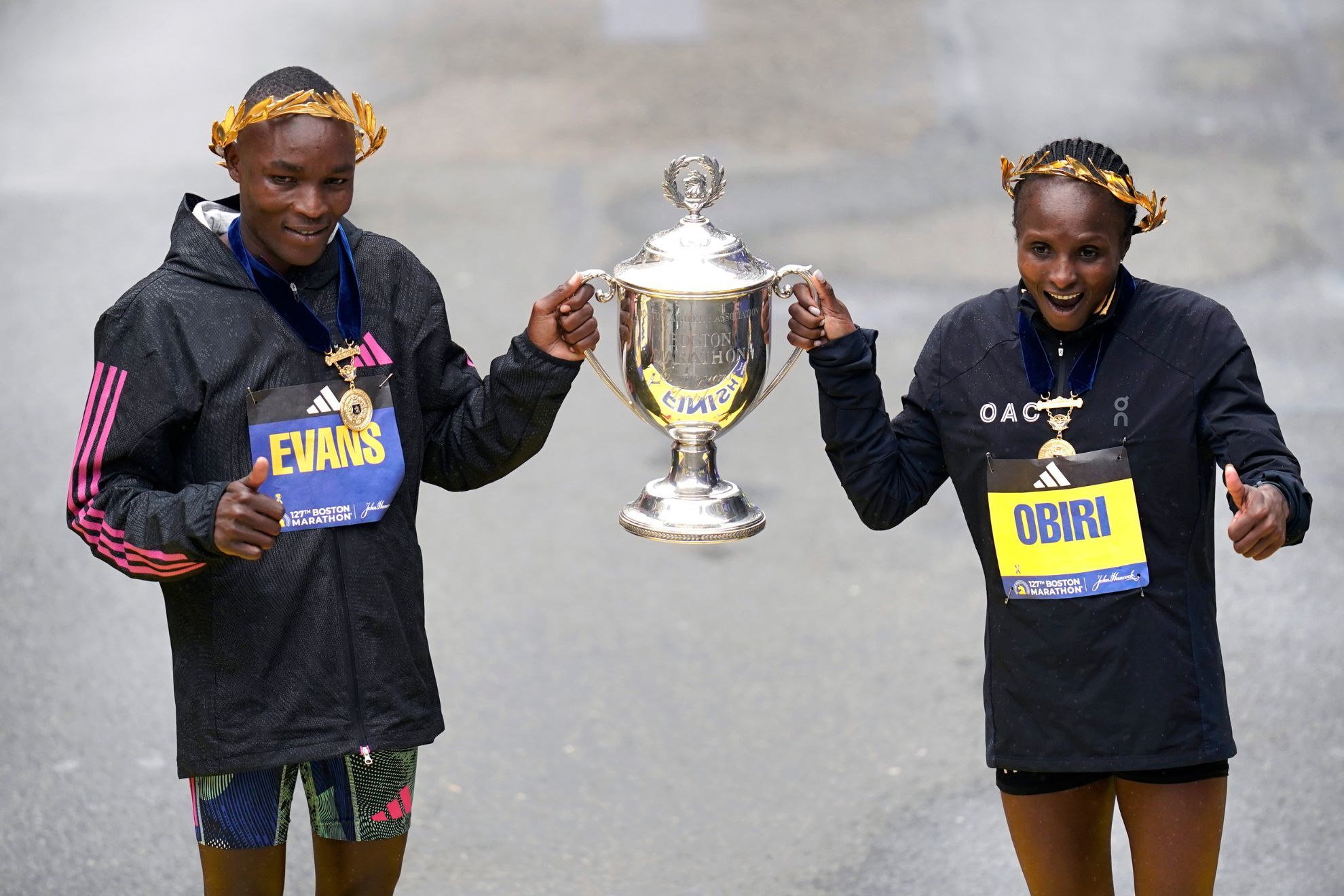 Evans Chebet and Hellen Obiri hold the Boston Marathon trophy.