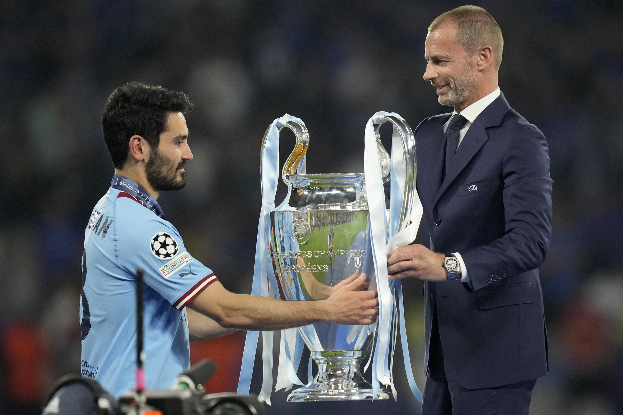 Ceferin le entrega la copa a G�ndogan.
