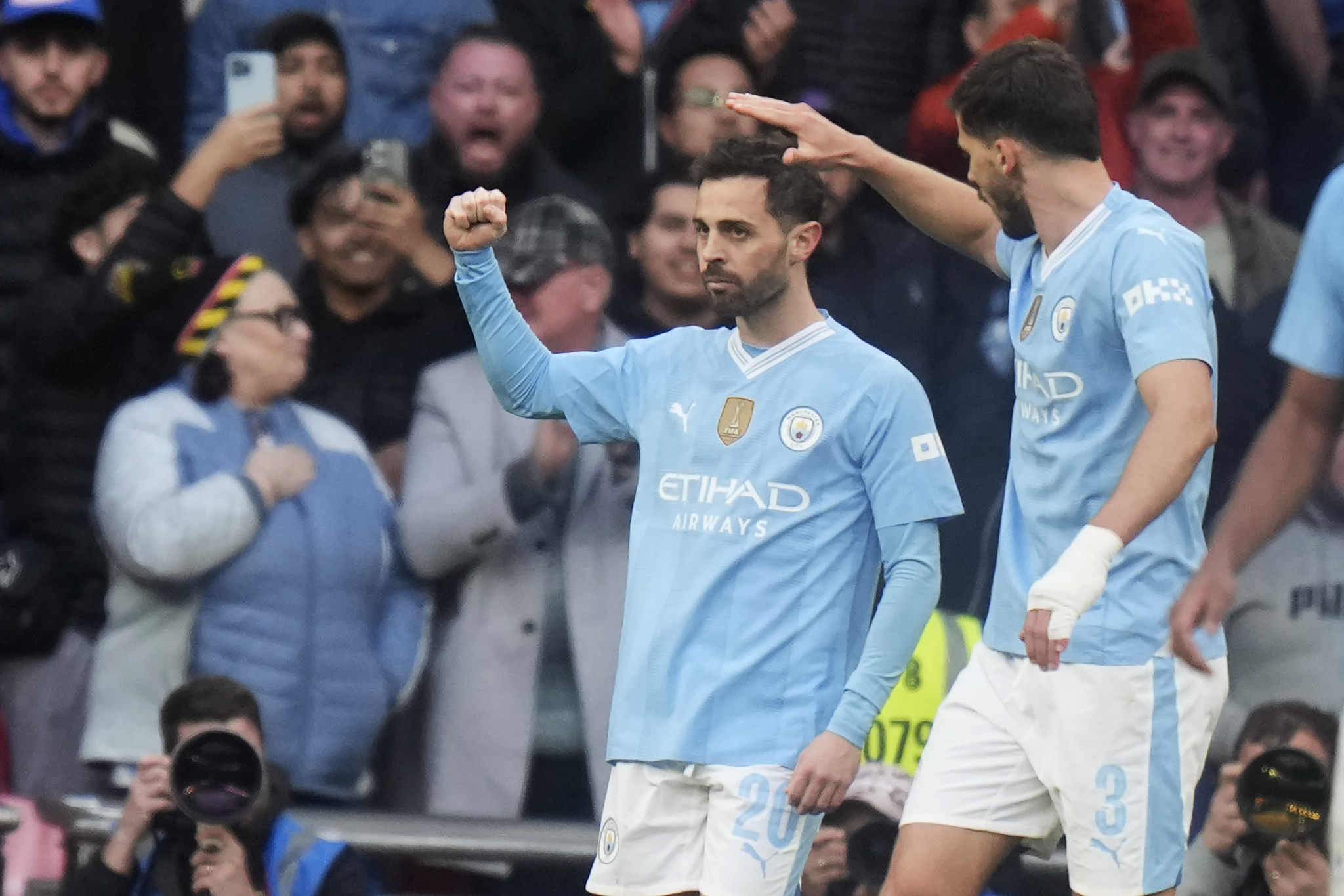 Manchester Citys Bernardo Silva, left, celebrates with teammates after scoring