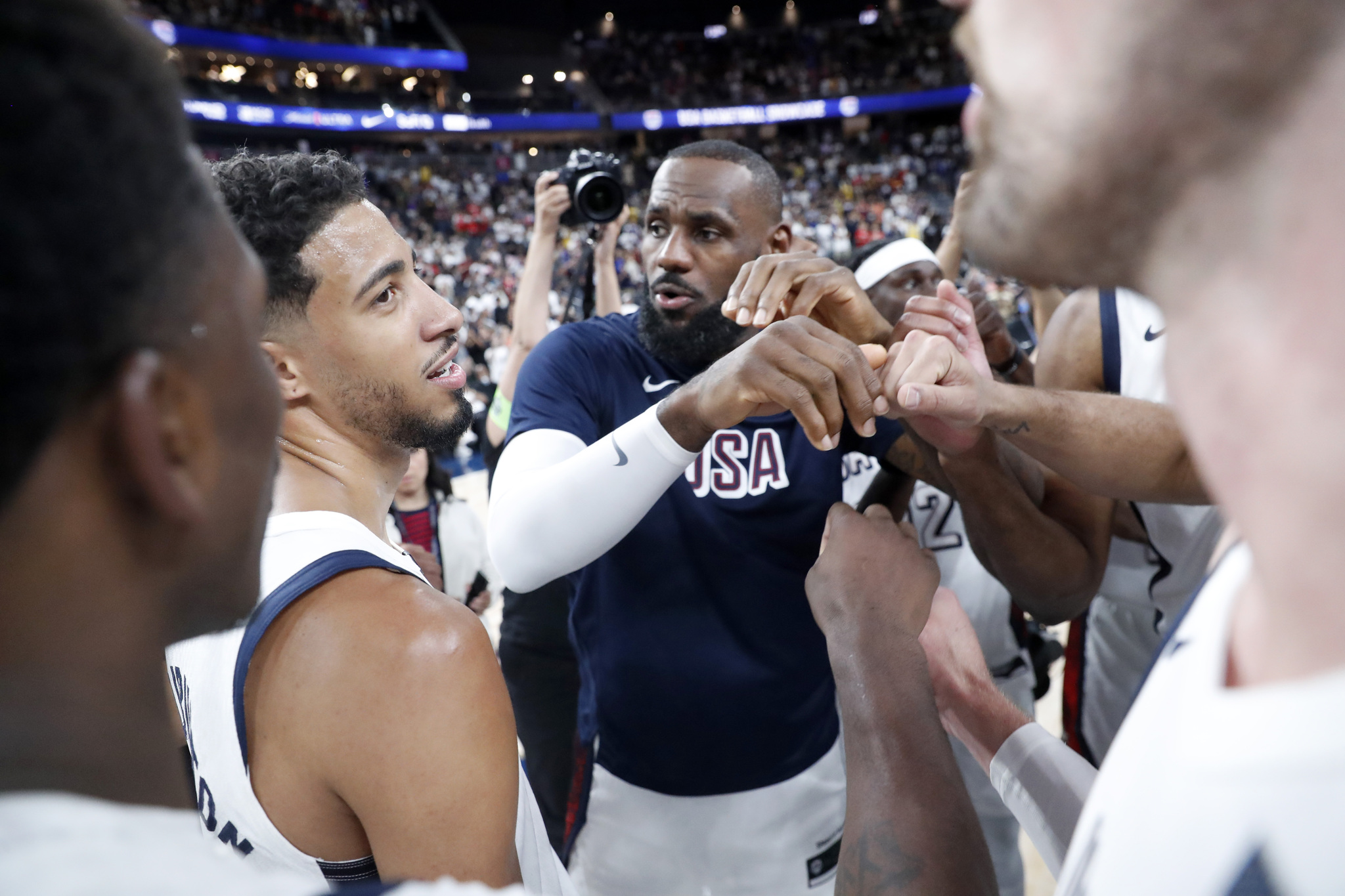 United States forward LeBron James, center, huddles with teammates after the United States beat Canada