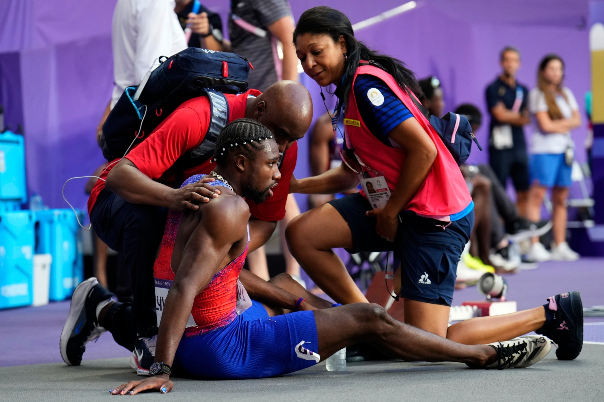Noah Lyles, of the United States, is treated by medical staff following the mens 200-meters final at the 2024 Summer Olympics, Thursday, Aug. 8, 2024, in Saint-Denis, France. (AP Photo/Petr David Josek)