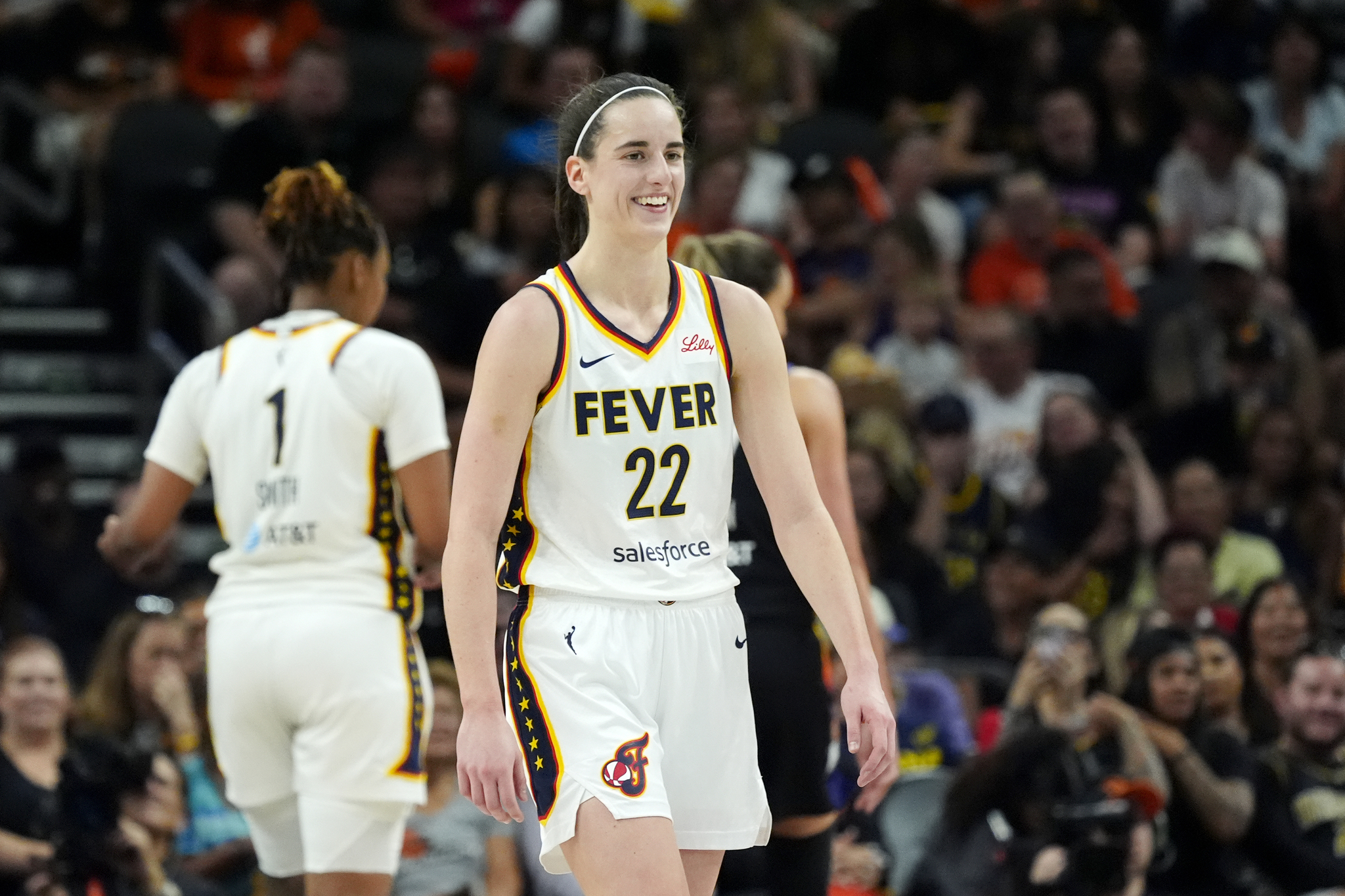 Indiana Fever guard Caitlin Clark smiles while pausing on the court during a WNBA basketball game