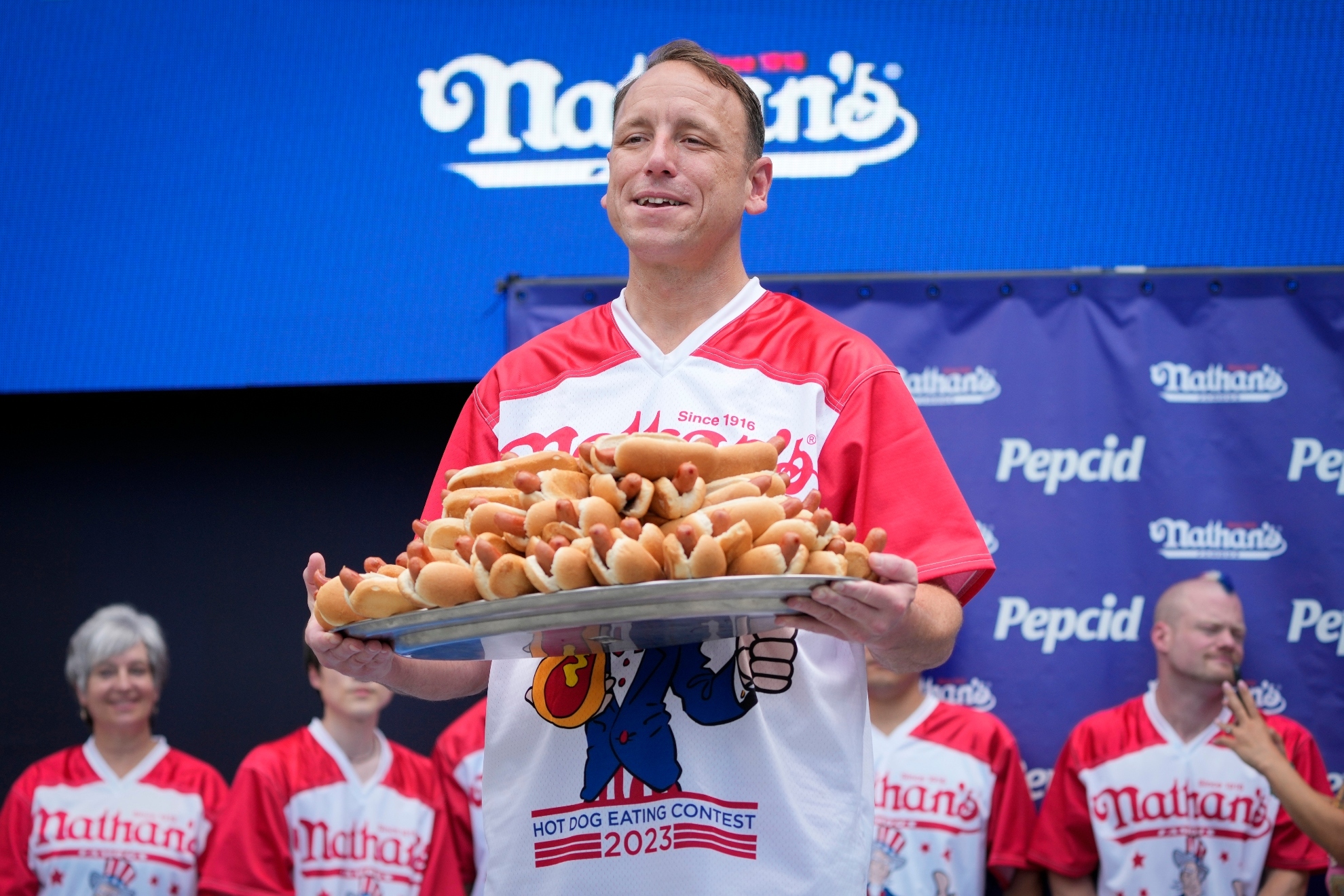 Competitive eater Joey Chestnut holds a plate of hotdogs representing his world record for eating 76 hotdogs and buns in ten minutes during a weigh-in ceremony before the Nathans Famous July Fourth hot dog eating contest