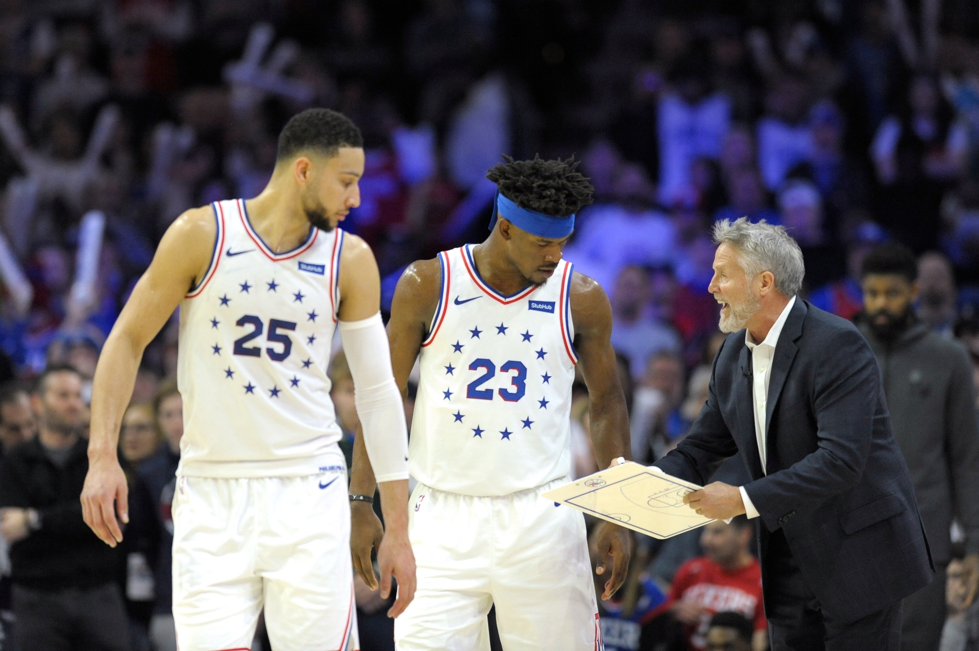 Philadelphia 76ers head coach Brett Brown, right, talks to Jimmy Butler (23) and Ben Simmons (25) during an NBA basketball game against the Oklahoma City Thunder, Saturday, Jan. 19, 2019, in Philadelphia