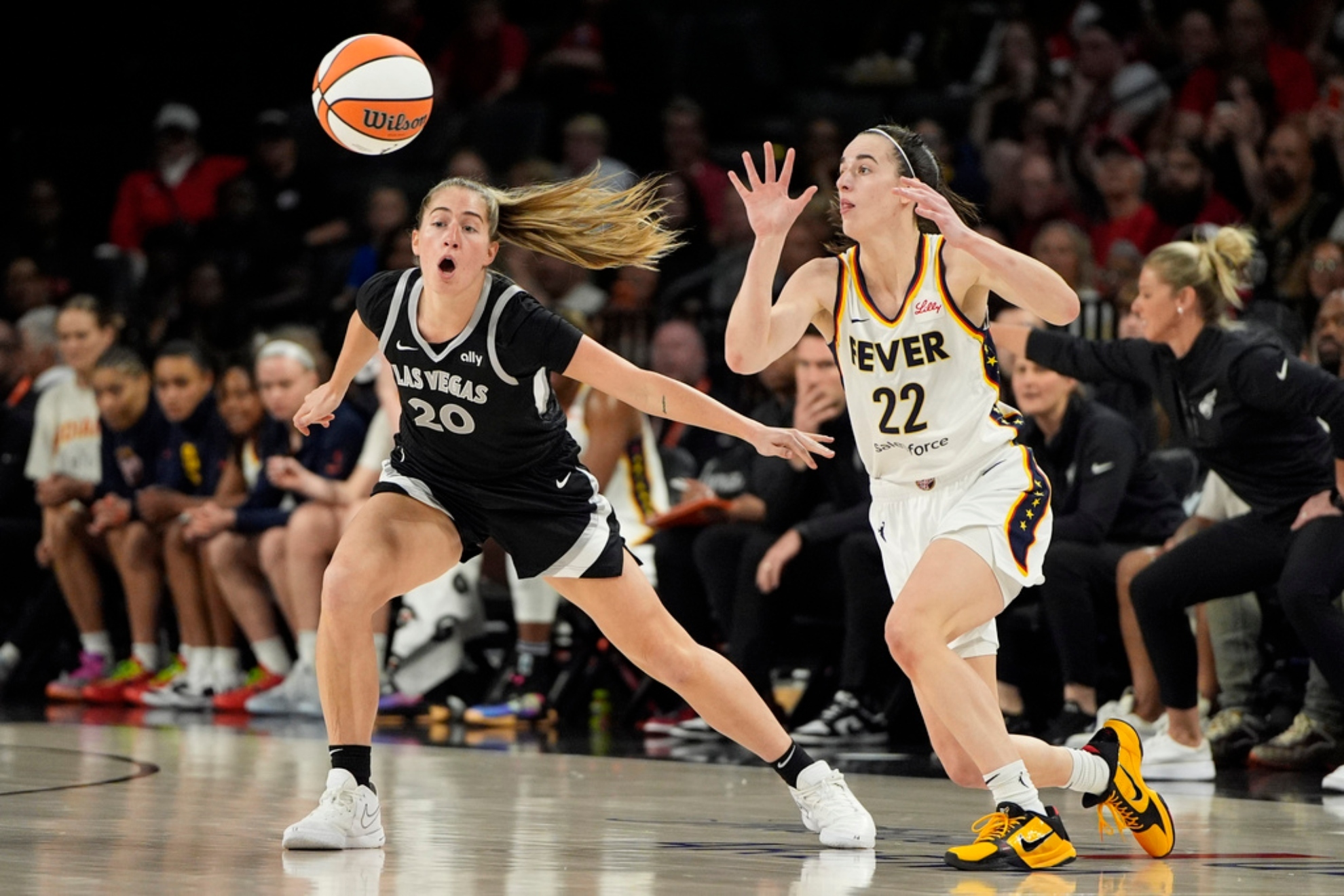 Indiana Fever guard Caitlin Clark (22) passes around Las Vegas Aces guard Kate Martin (20).