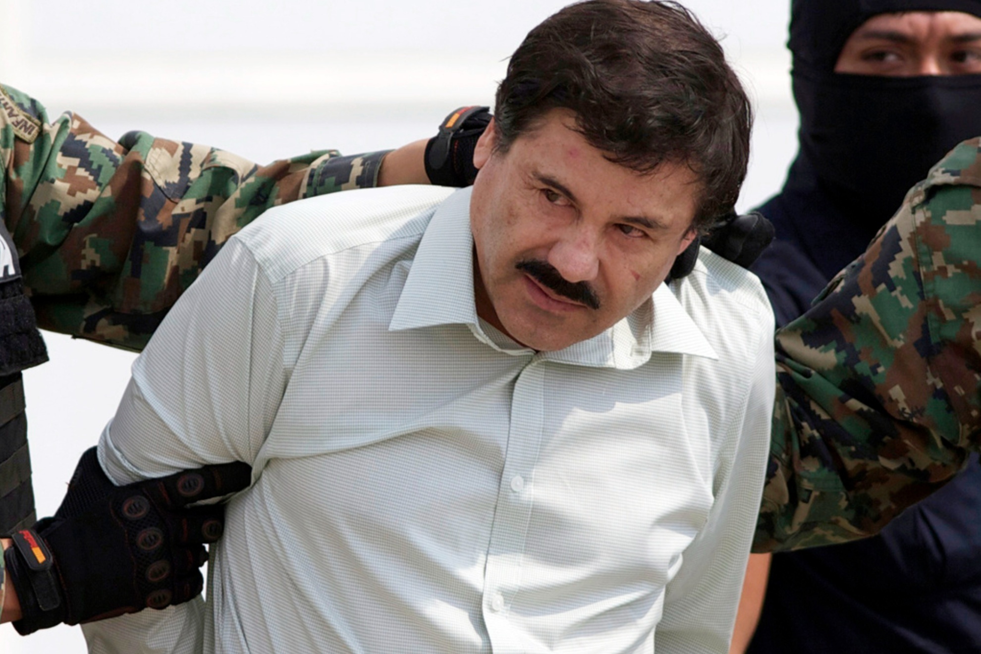 Joaquin El Chapo Guzman being escorted to a helicopter in Mexico City in 2014 following his capture