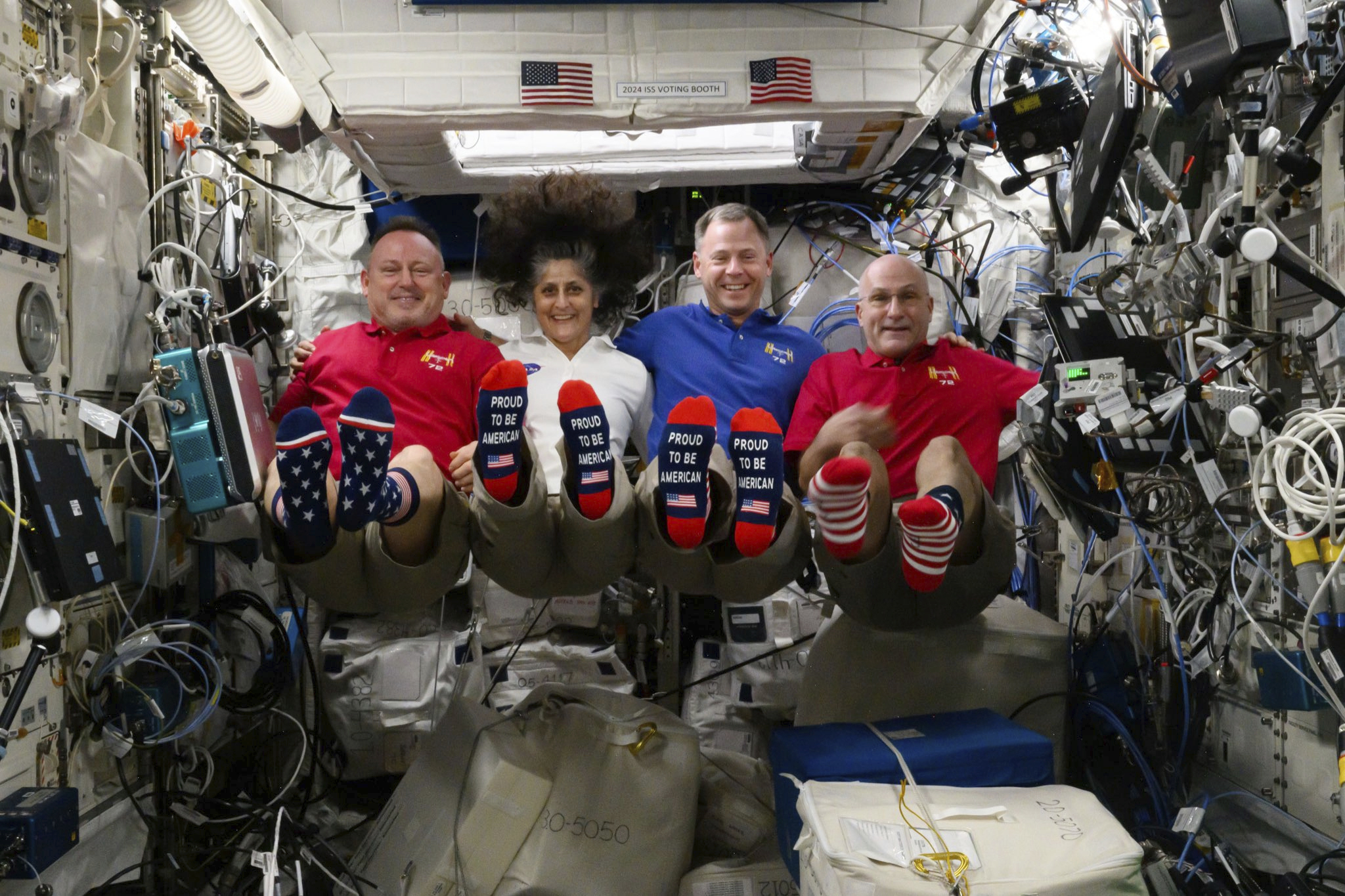 Astronauts Butch Wilmore, Suni Williams, Nick Hague and Don Pettit show their U.S. flag-themed socks