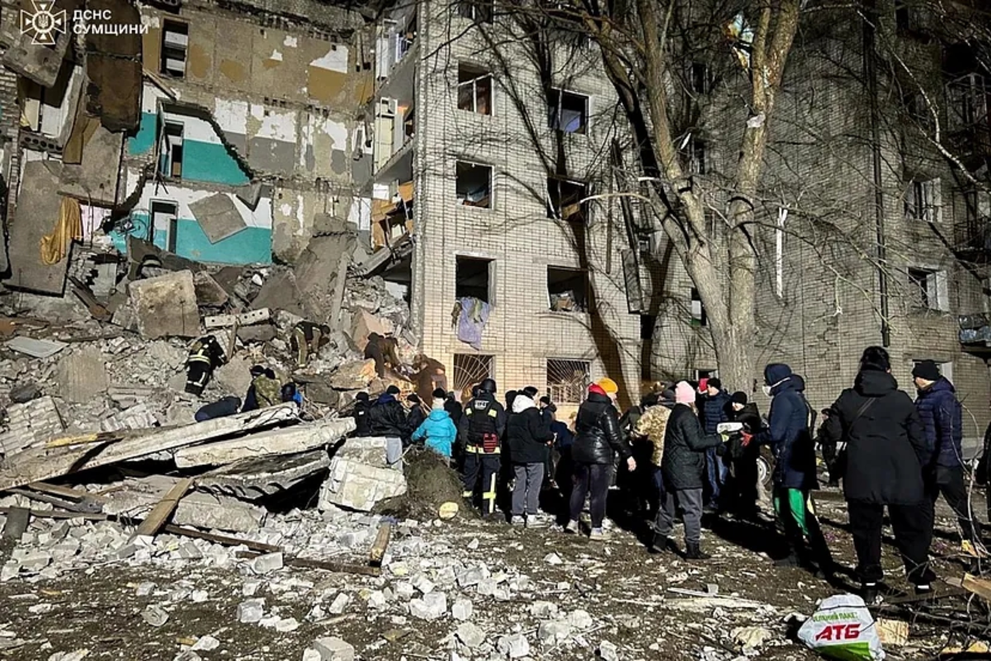 Rescue workers and volunteers clear debris from a residential building destroyed by a Russian attack in Hlukhiv, Ukraine.