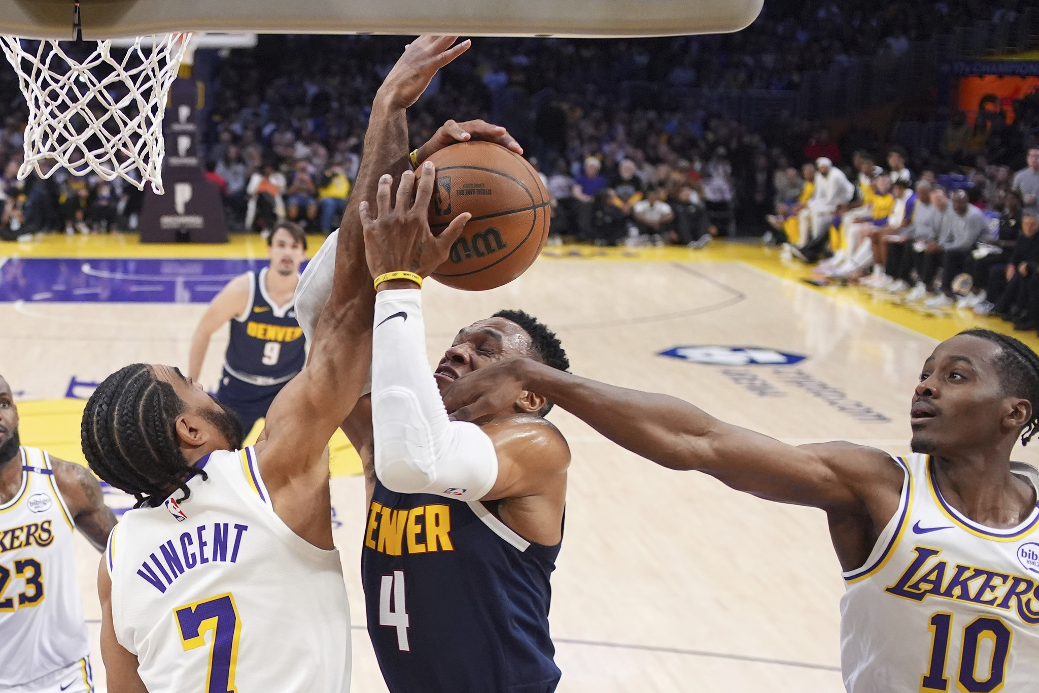 Denver Nuggets guard Russell Westbrook center, shoots as Lakers guard Gabe Vincent, left, and center Christian Koloko defend