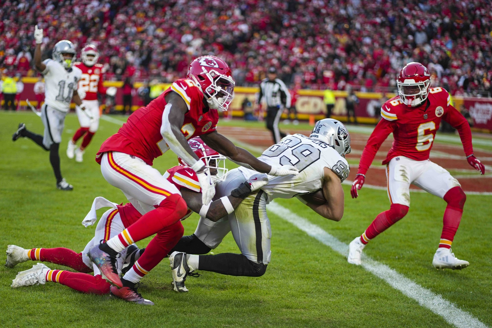 Las Vegas Raiders tight end Brock Bowers (89) dives in for a touchdown as hes hit by Kansas City Chiefs cornerback Joshua Williams, top, left, safety Chamarri Conner, bottom left,