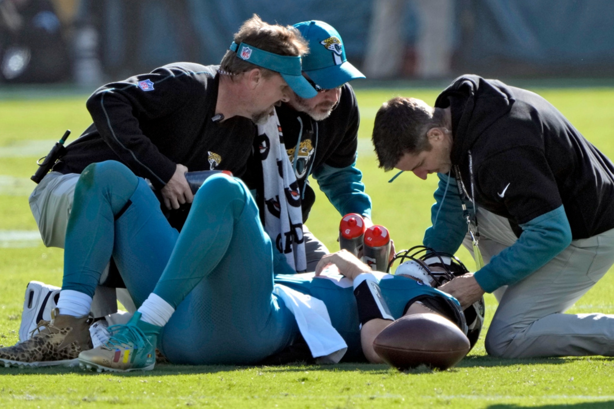 The Jaguars medical staff tending to Trevor Lawrence after Azeez Al-Shaairs hit.