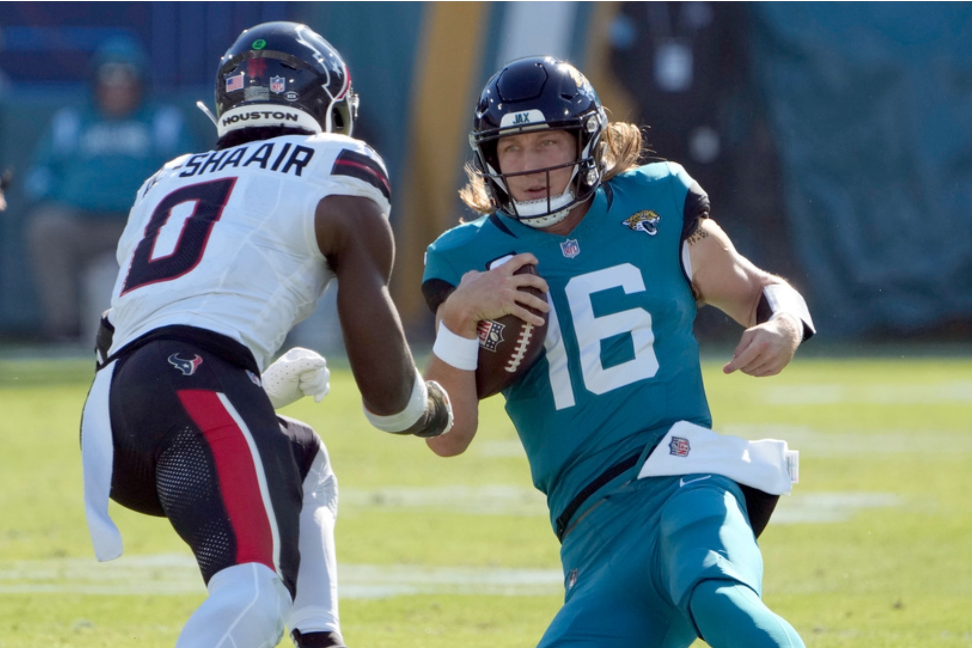 Jaguars Trevor Lawrence slides in front of Texans Azeez Al-Shaair in a Week 13 NFL game