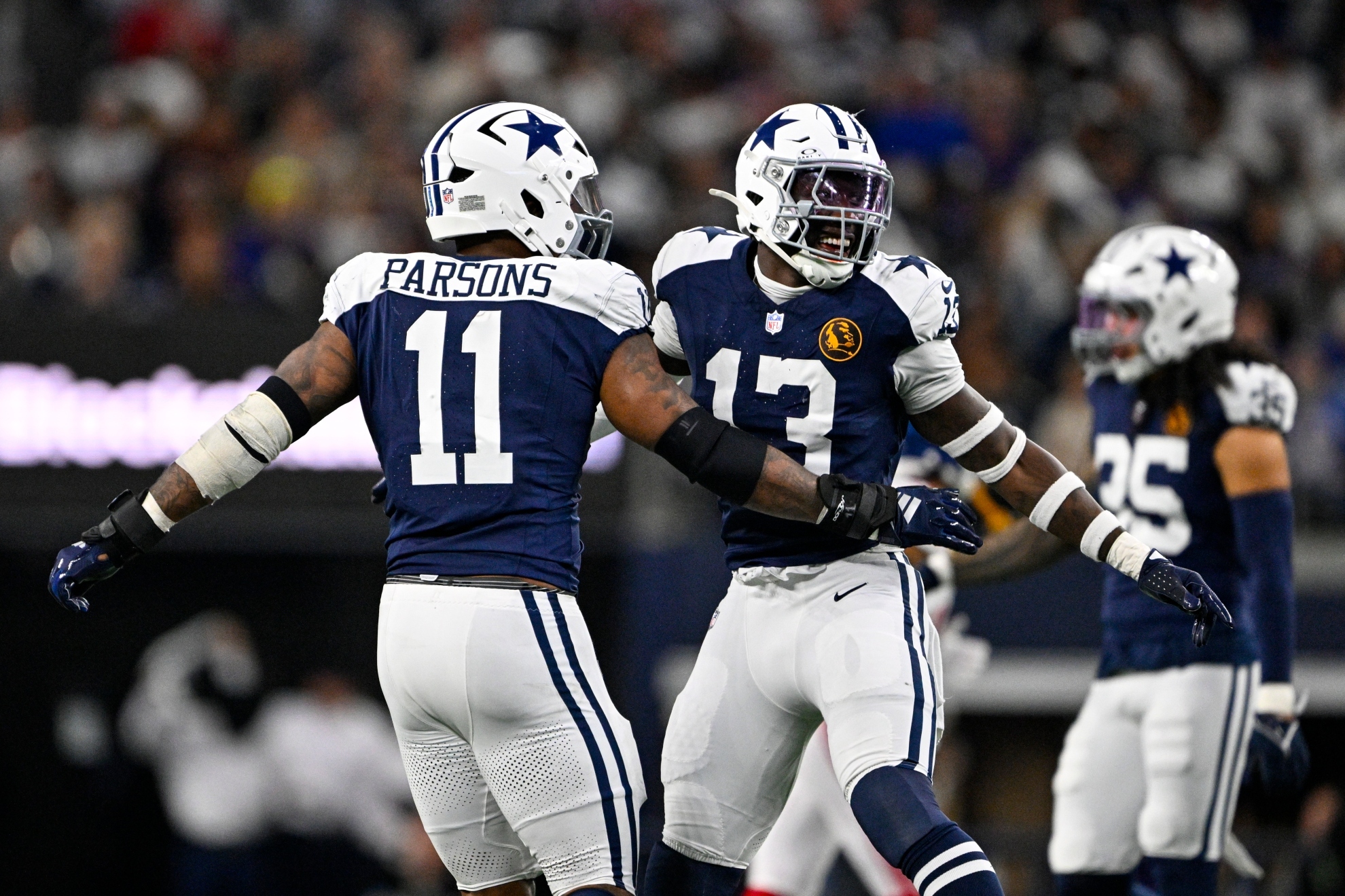 Dallas Cowboys linebackers Micah Parsons (11) and DeMarvion Overshown (13) celebrate a sack against the New York Giants during the first half of an NFL football game in Arlington, Texas, Thursday, Nov. 28, 2024. (AP Photo/Jerome Miron)