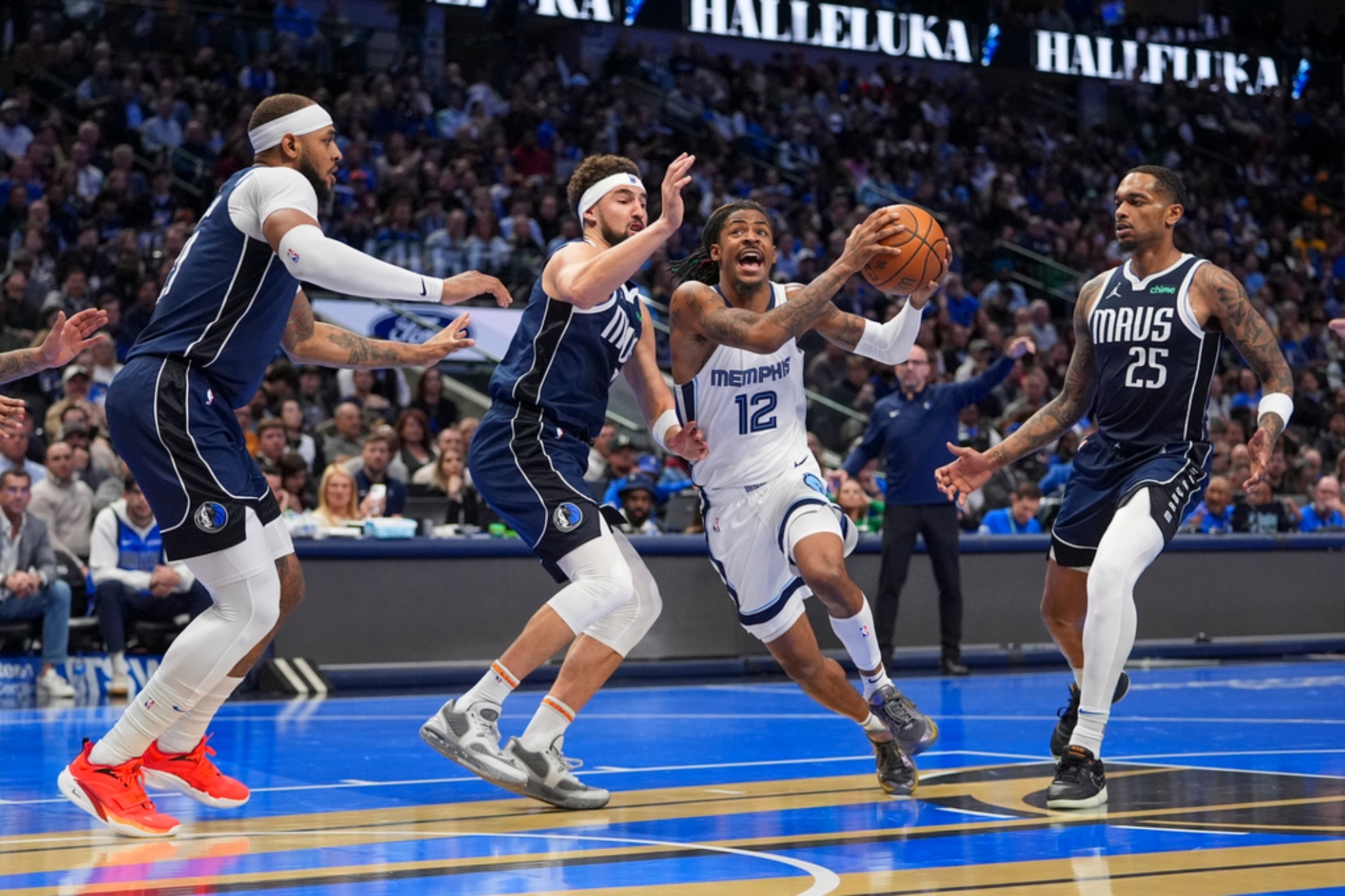 Ja Morant (12) drives to the basket against Dallas Mavericks Gafford, left, Thompson, second from left, and Washington (25).
