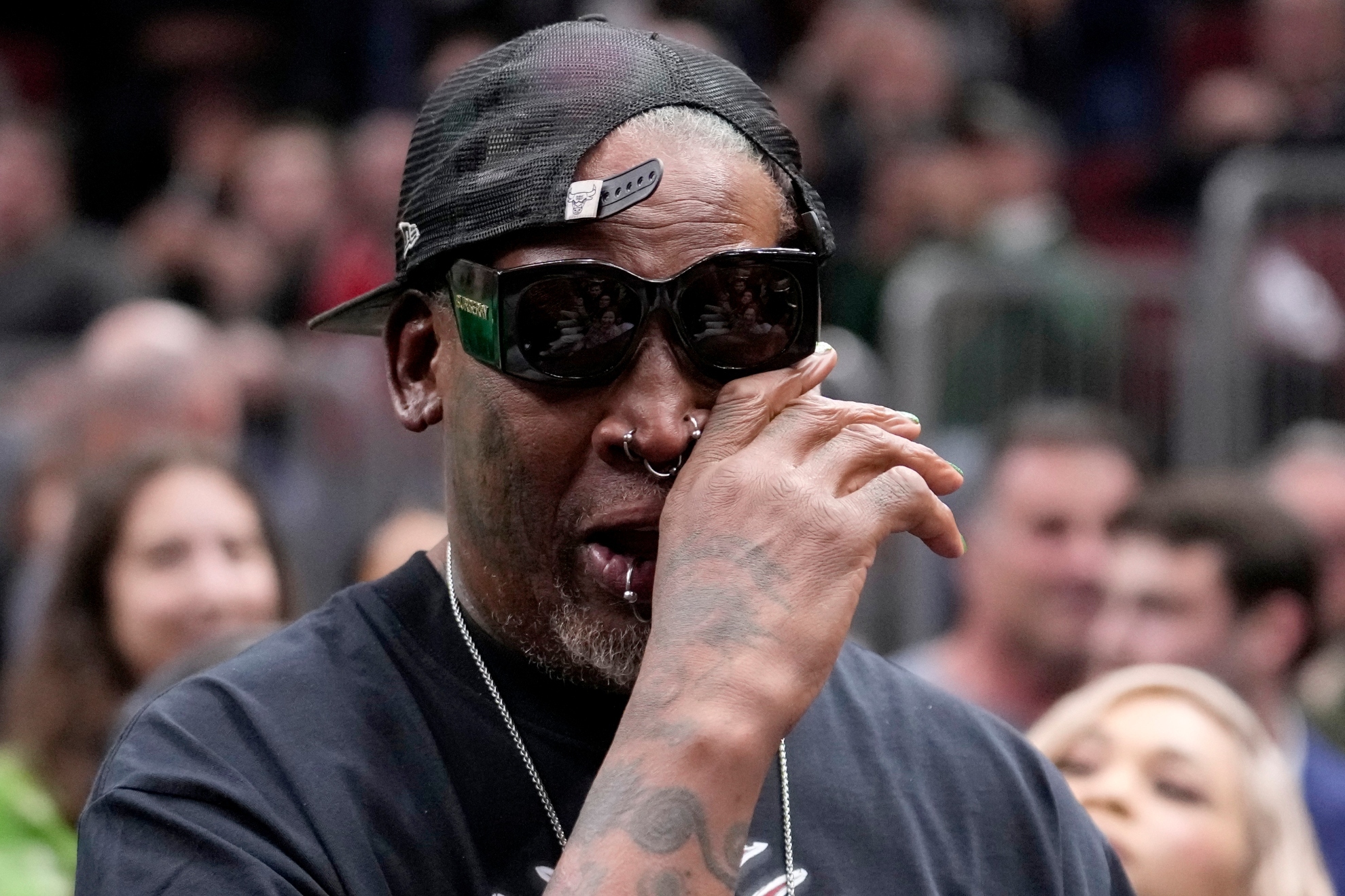 Former Chicago Bulls Dennis Rodman wipes his eye and listens to the crowd chant his name as he makes a courtside appearance before an NBA basketball game between the Bulls and the Washington Wizards, Saturday, March 16, 2024, in Chicago.