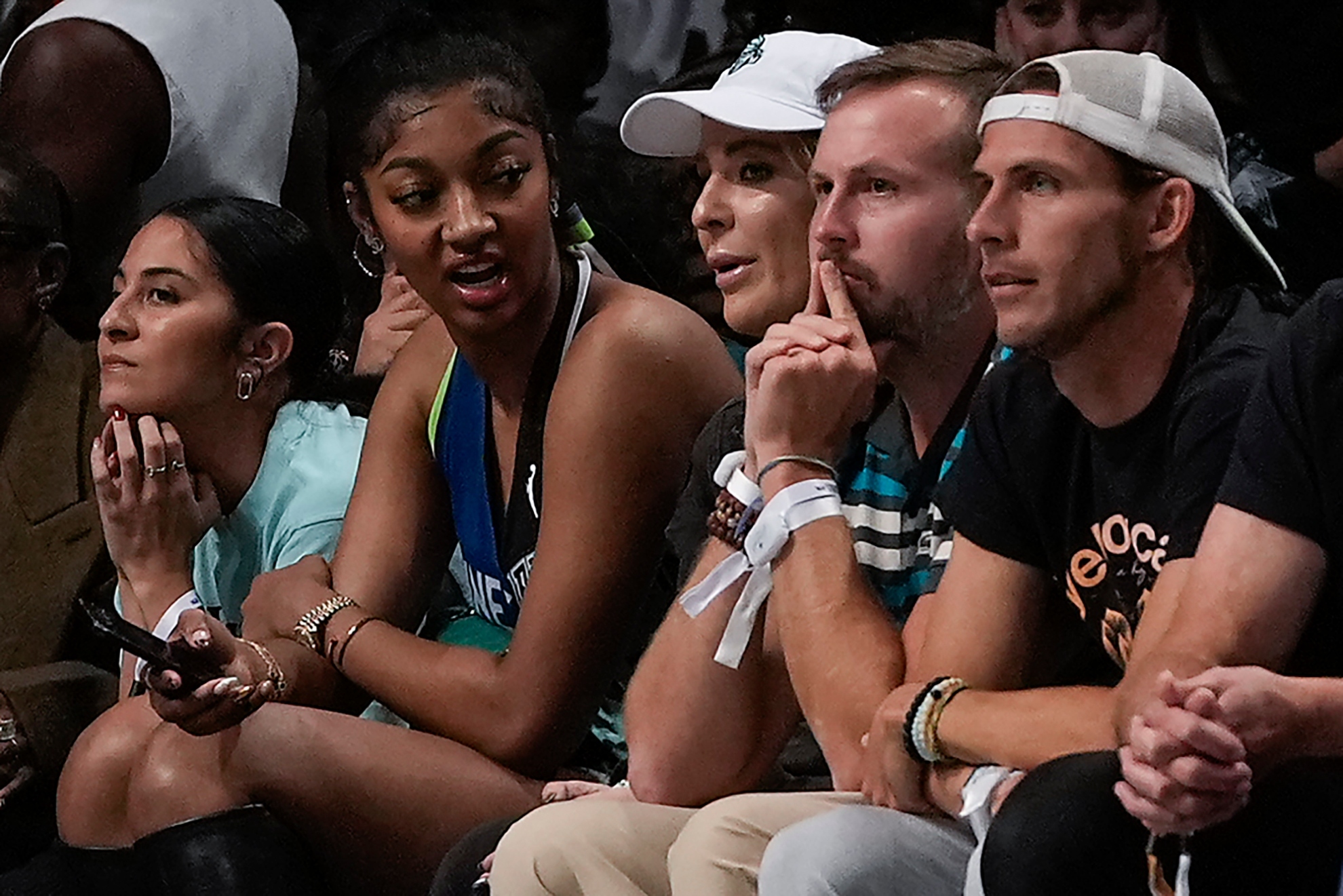 Angel Reese, second from left, watches play between the New York Liberty and the Minnesota Lynx during Game 5 of the WNBA basketball final series, Sunday, Oct. 20, 2024, in New York.