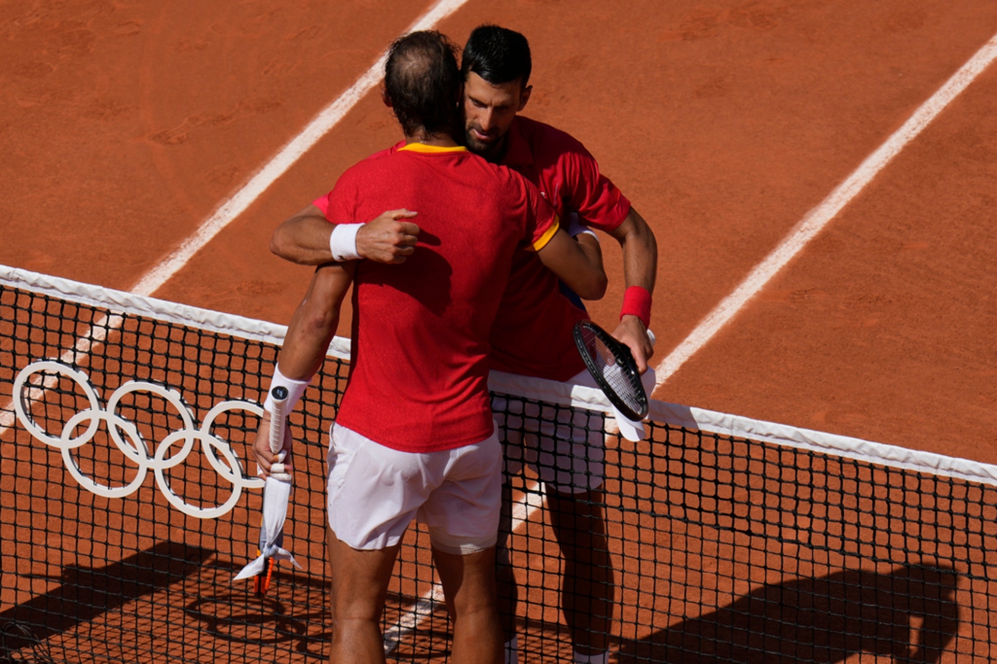 Djokovic, right, hugs Spains Rafael Nadal after their mens singles second round match at the Roland Garros stadium.