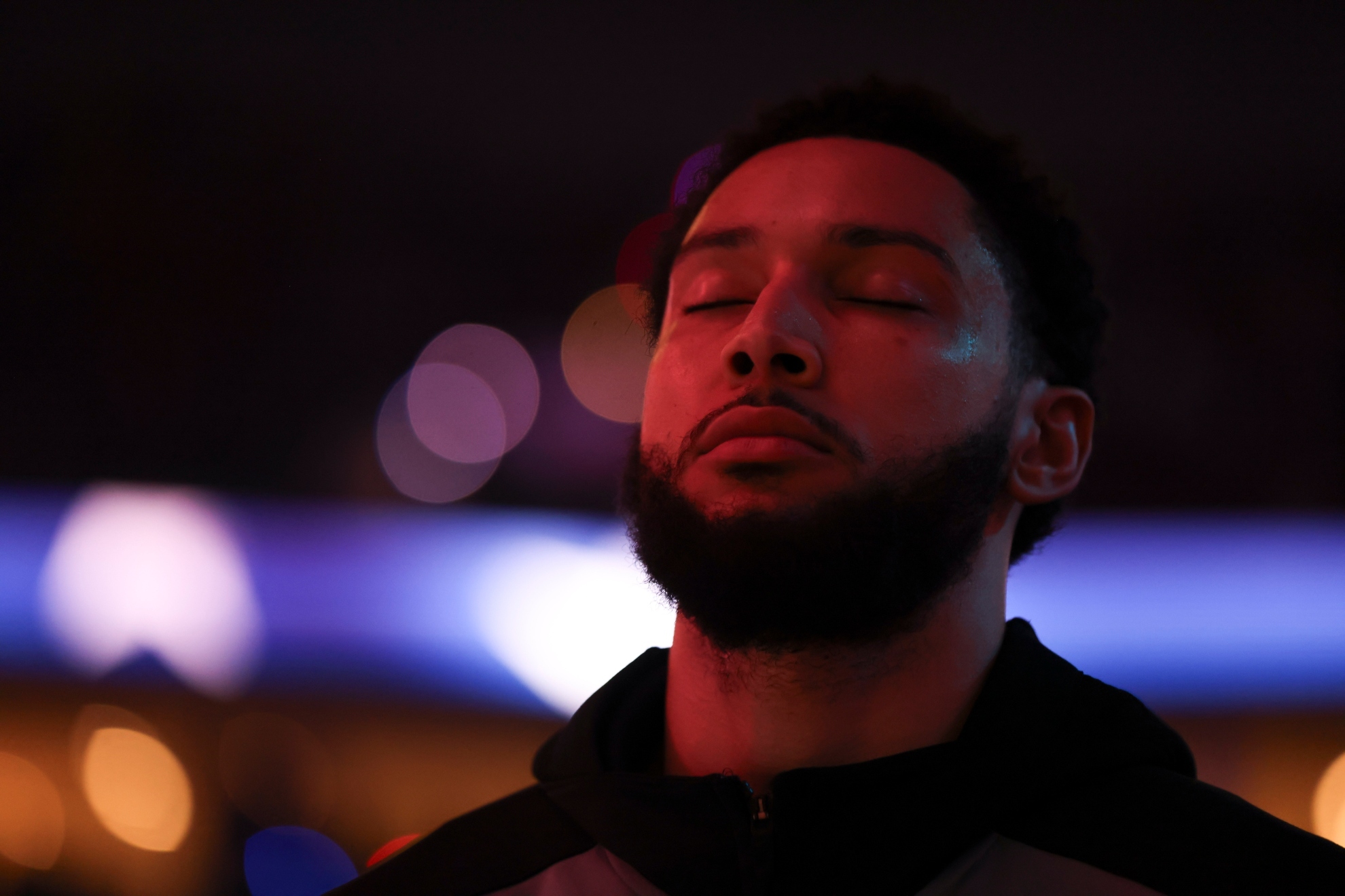 Ben Simmons stands for the National Anthem before a basketball game.