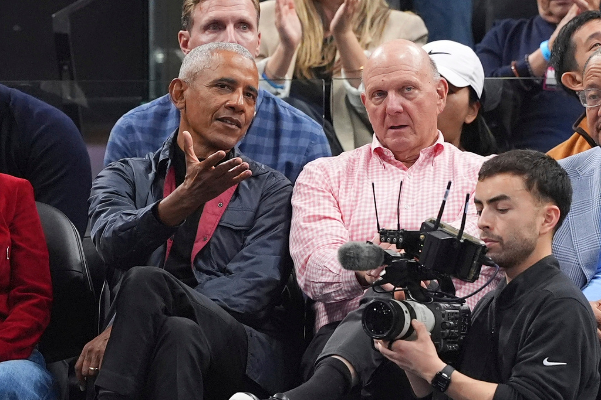 Former President Barack Obama, left, sits with Los Angeles Clippers owner Steve Ballmer during the first half of an NBA basketball game.