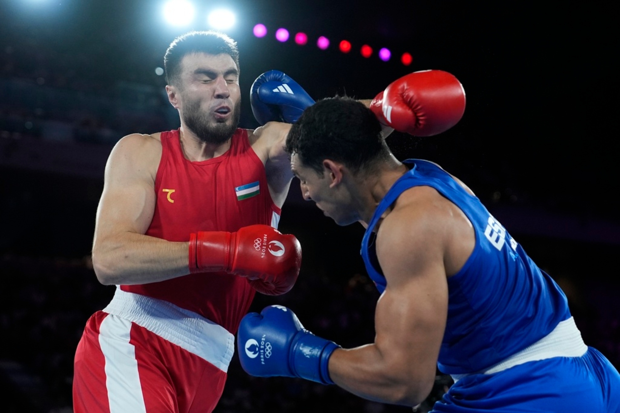 Uzbekistans Bakhodir Jalolov, left, fights Spains Ayoub Ghadfa in their mens +92 kg final boxing match at the 2024 Summer Olympics.