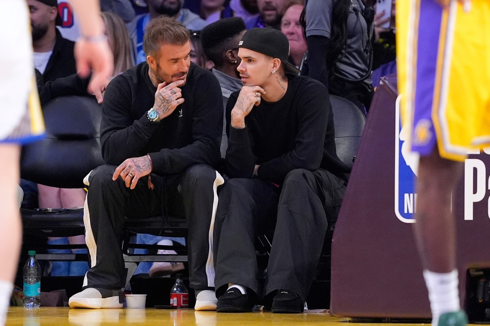 David Beckham sits with his son Romeo as they watch the Los Angeles Lakers vs the Golden State Warriors.