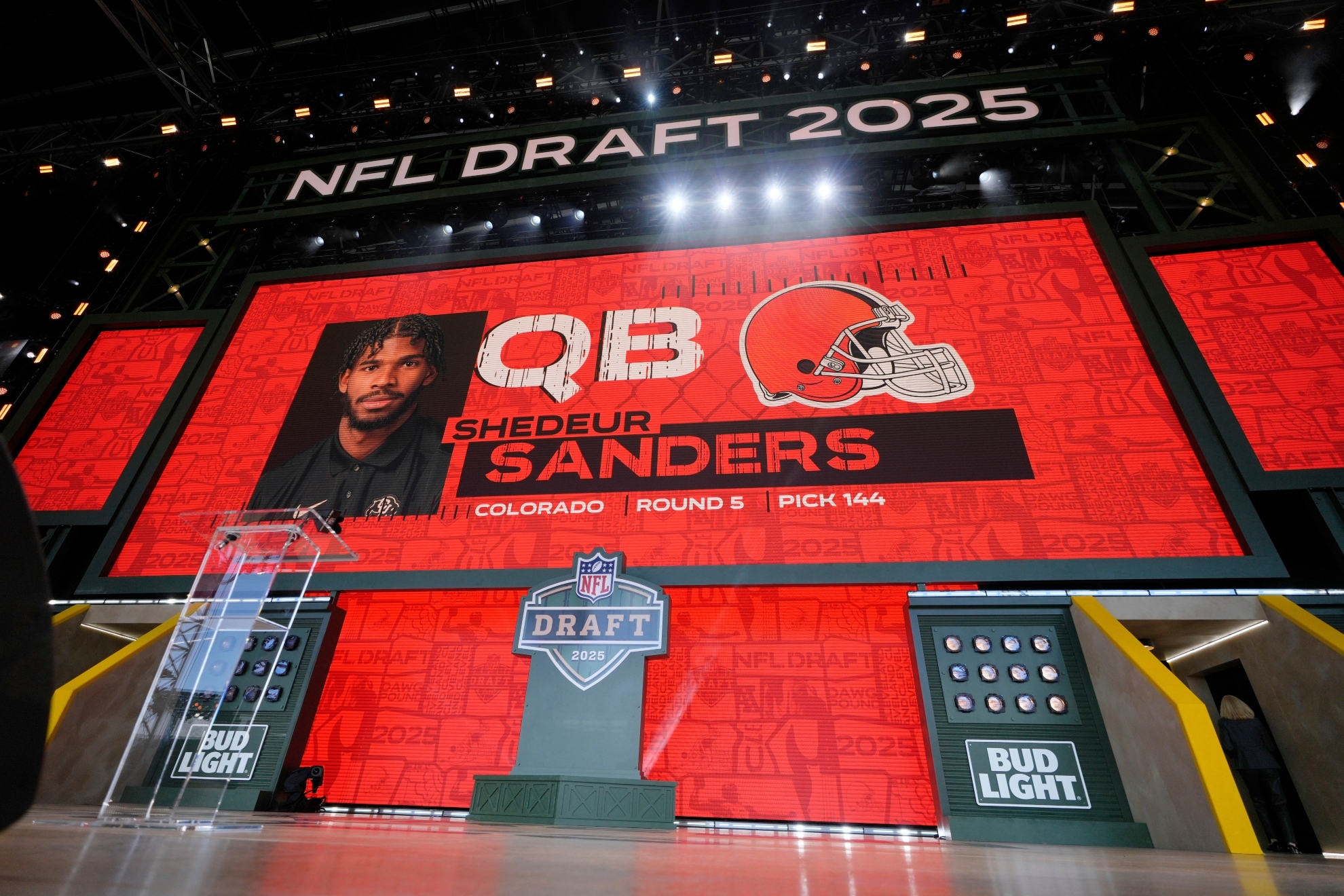 A screen shows Colorado quarterback Shedeur Sanders after being chosen by the Cleveland Browns in the 2025 NFL Draft.