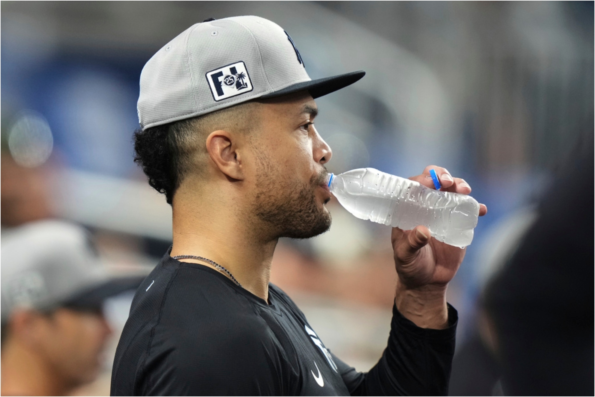New York Yankees Giancarlo Stanton stands in the dugout.