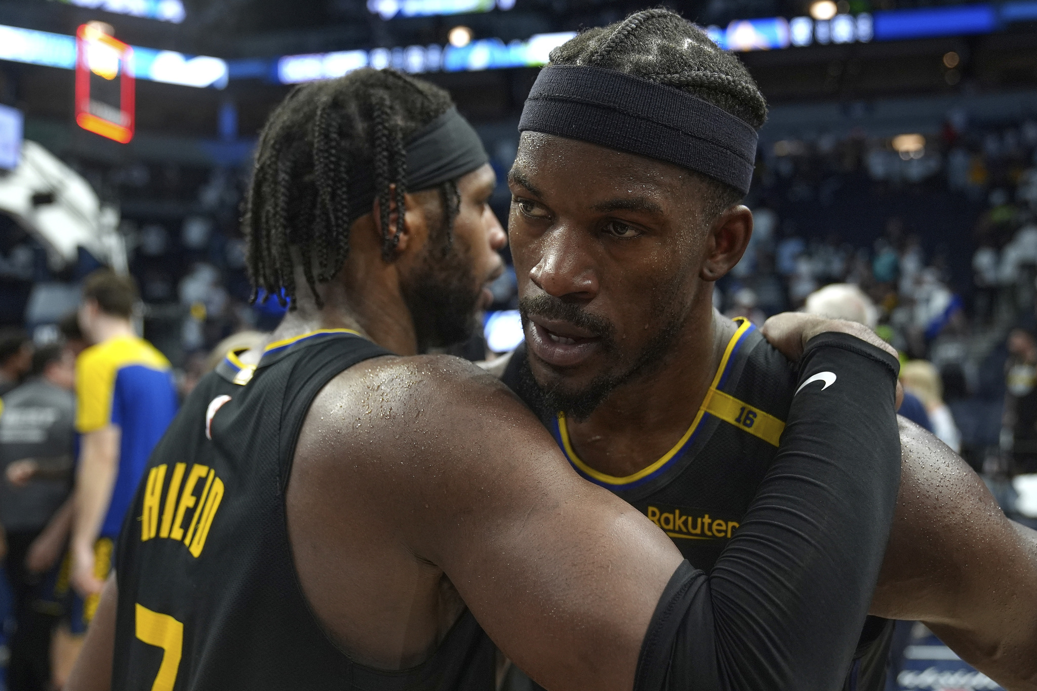 Golden State Warriors guard Buddy Hield (7), left, and forward Jimmy Butler (10) hug after Game 1 against Minnesota