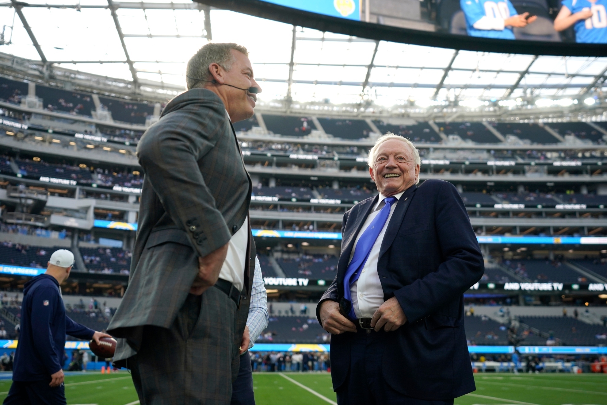 Troy Aikman and Cowboys owner Jerry Jones speak before an NFL game.