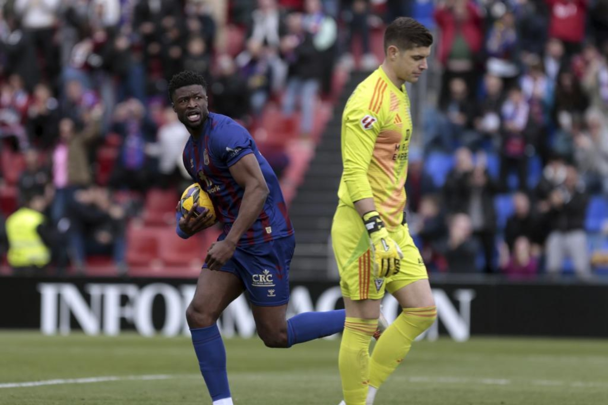 Gassama, asistente en el 2-1 del Eldense, corre con el bal�n ante la decepci�n de Fern�ndez.