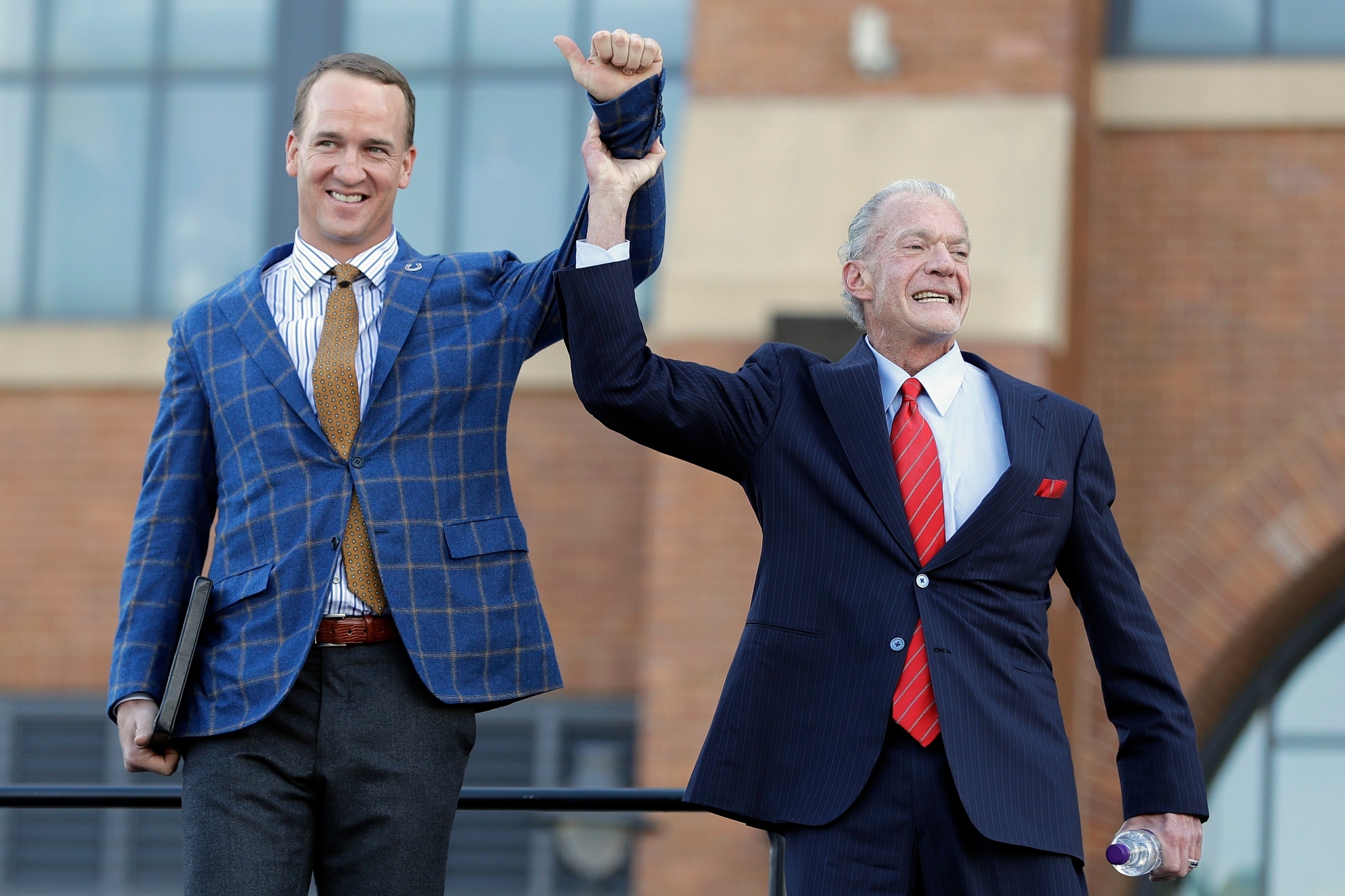 Peyton Manning and Indianapolis Colts owner Jim Irsay acknowledge fans during the unveiling of a Peyton Manning statue outside of Lucas Oil Stadium.
