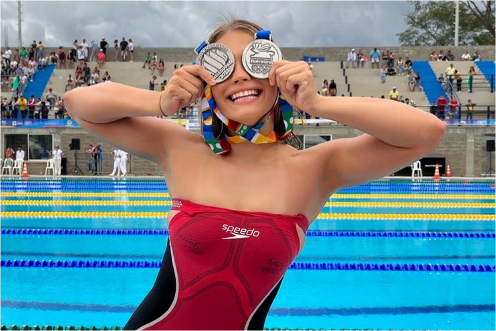 Luana Alonso shows two medals won in a swimming competition.