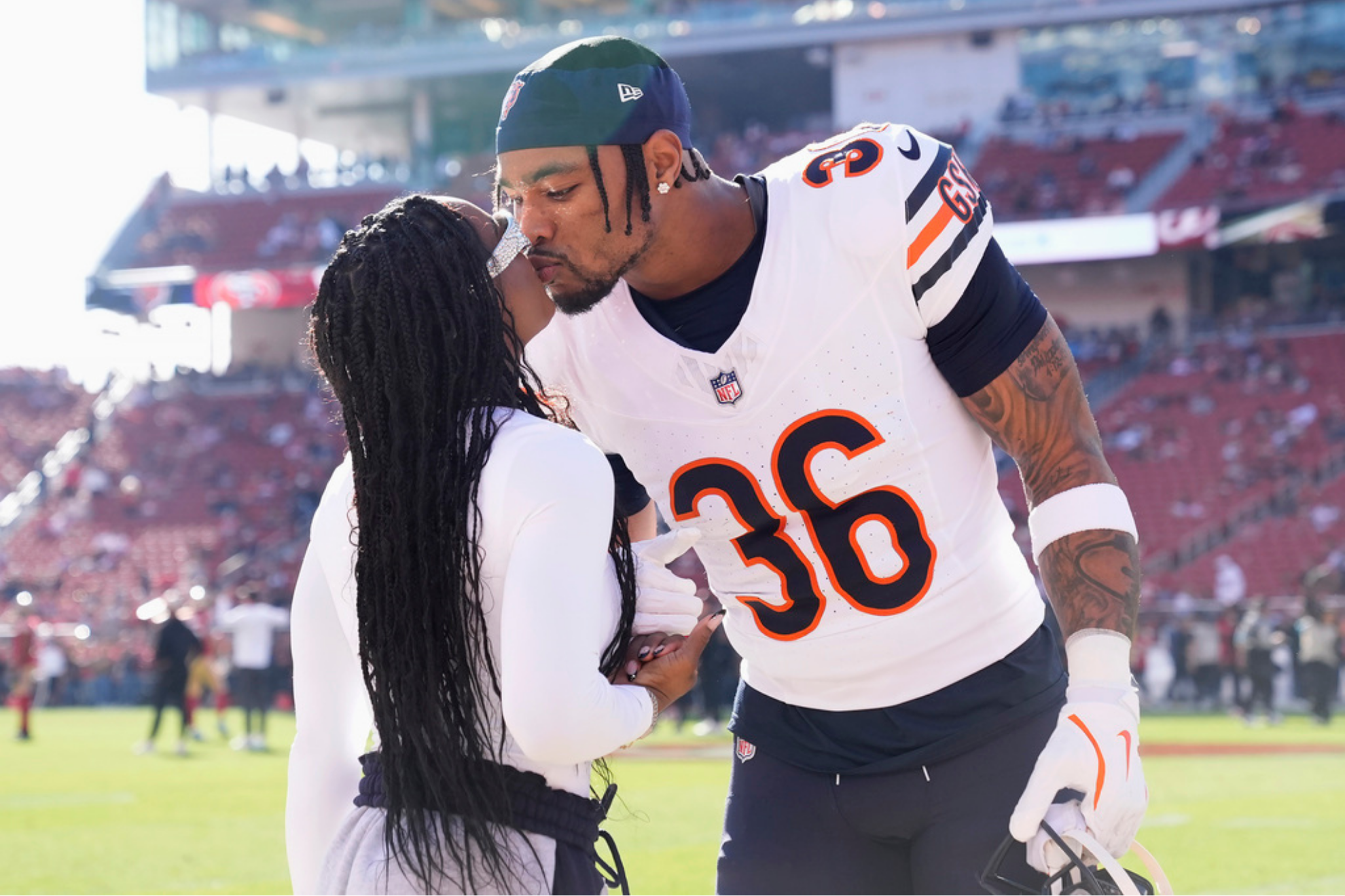 Chicago Bears safety Jonathan Owens kisses his wife, Siimone Biles