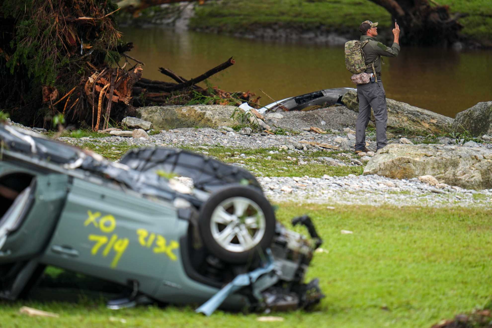 Officials comb through the banks of the Guadalupe River after a flash flood swept through the area Saturday, July 5, 2025, in Hunt, Texas.