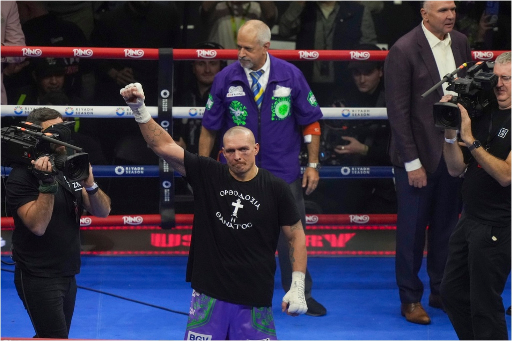 Ukraines Oleksandr Usyk celebrates after winning the WBA, WBO, and WBC world heavyweight title.