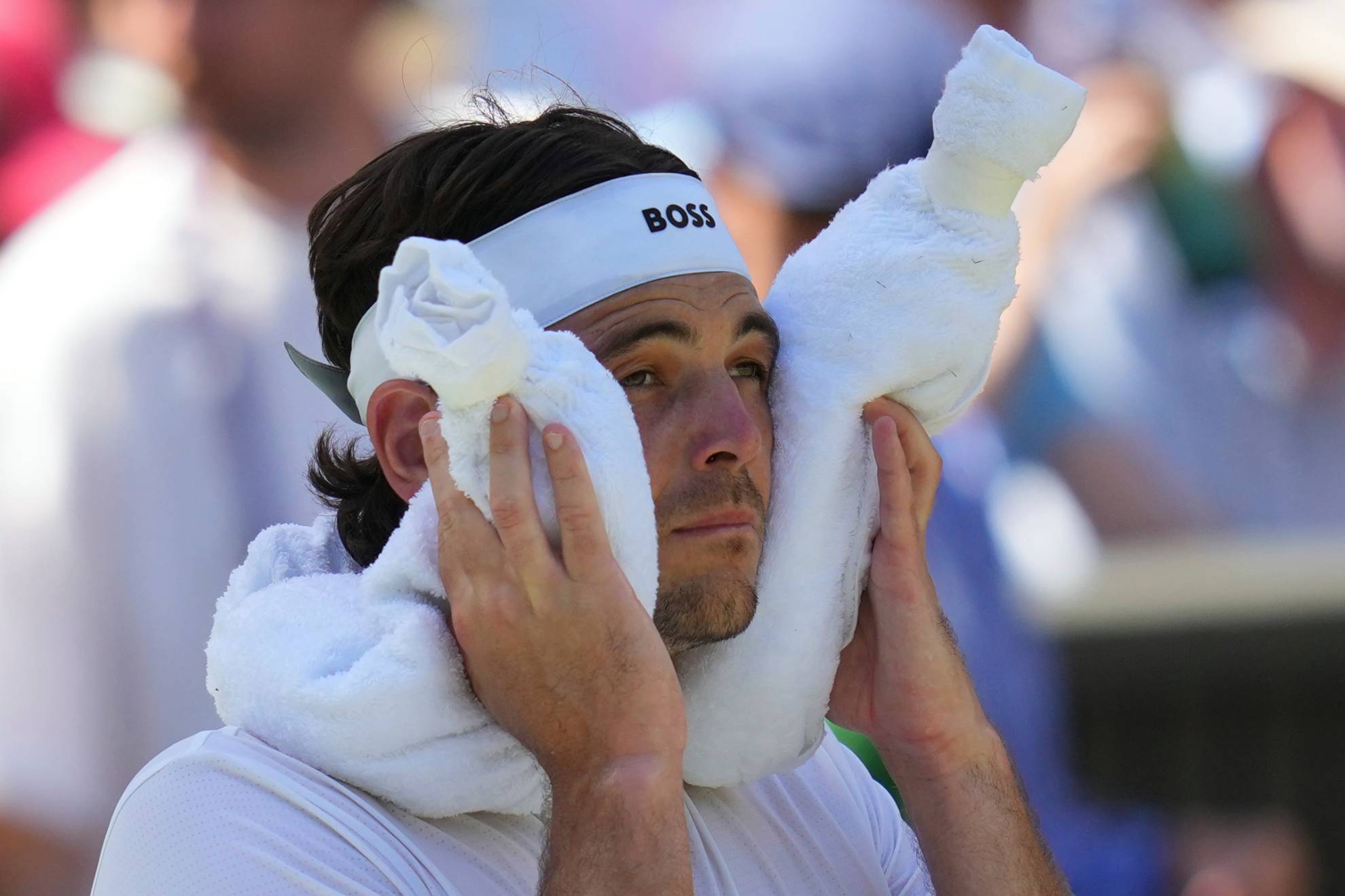 Taylor Fritz of the U.S. uses a towel packed with ice to cool during the mens semifinal singles match /