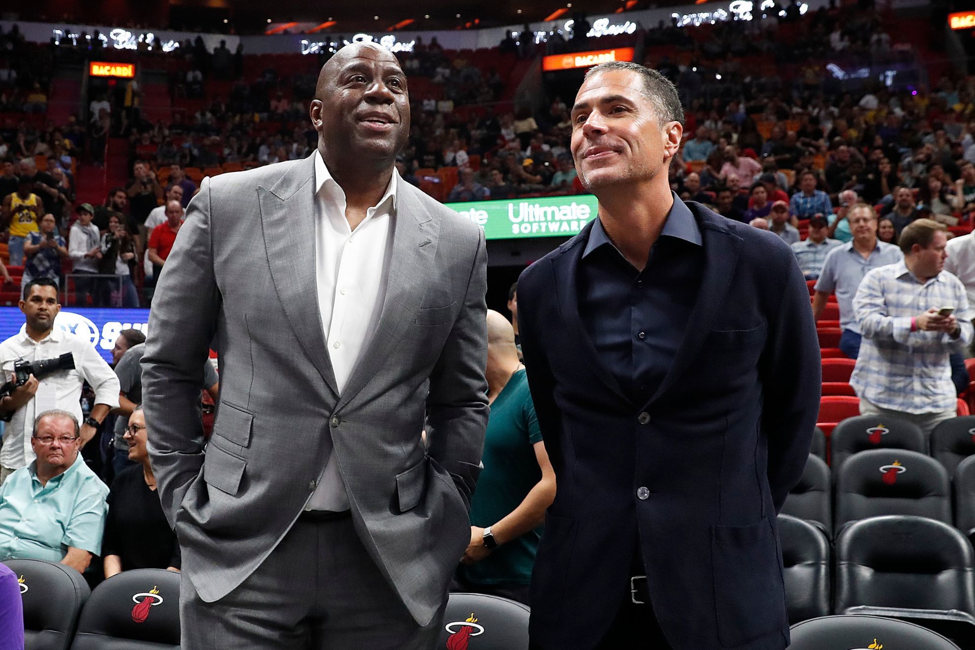 Los Angeles Lakers general manager Rob Pelinka, right, speaks with Lakers president of basketball operations Magic Johnson, left, before before an NBA basketball game