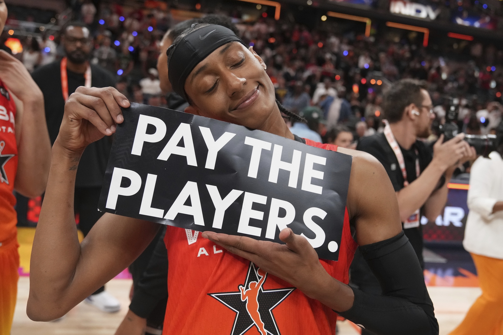 Washington Mystics Brittney Sykes holds a sign following a WNBA All-Star basketball game against Team Collier, Saturday, July 19, 2025, in Indianapolis. (AP Photo/Michael Conroy)