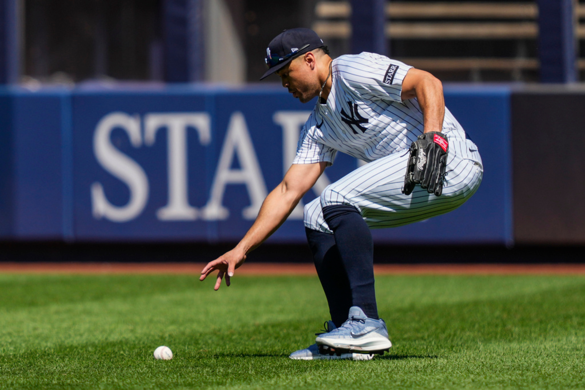 New York Yankees outfielder Giancarlo Stanton picks up a ball hit by Houston Astros Jes�s S�nchez (4) during the fourth inning of a baseball game against the Houston Astros, Saturday, Aug. 9, 2025, in New York.