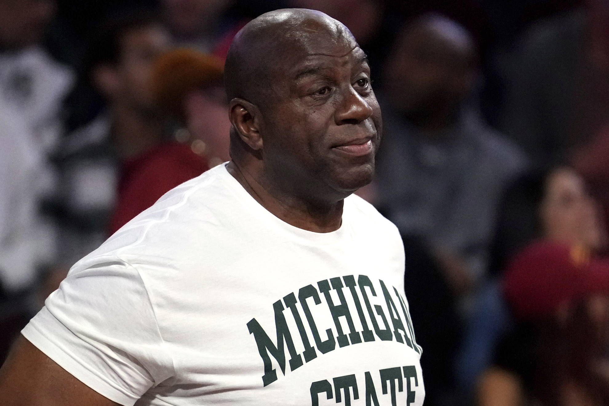 Former NBA player Magic Johnson, center, watches looks on during the second half of an NCAA college basketball game between Southern California and Michigan State, Saturday, Feb. 1, 2025, in Los Angeles. (AP Photo/Mark J. Terrill)