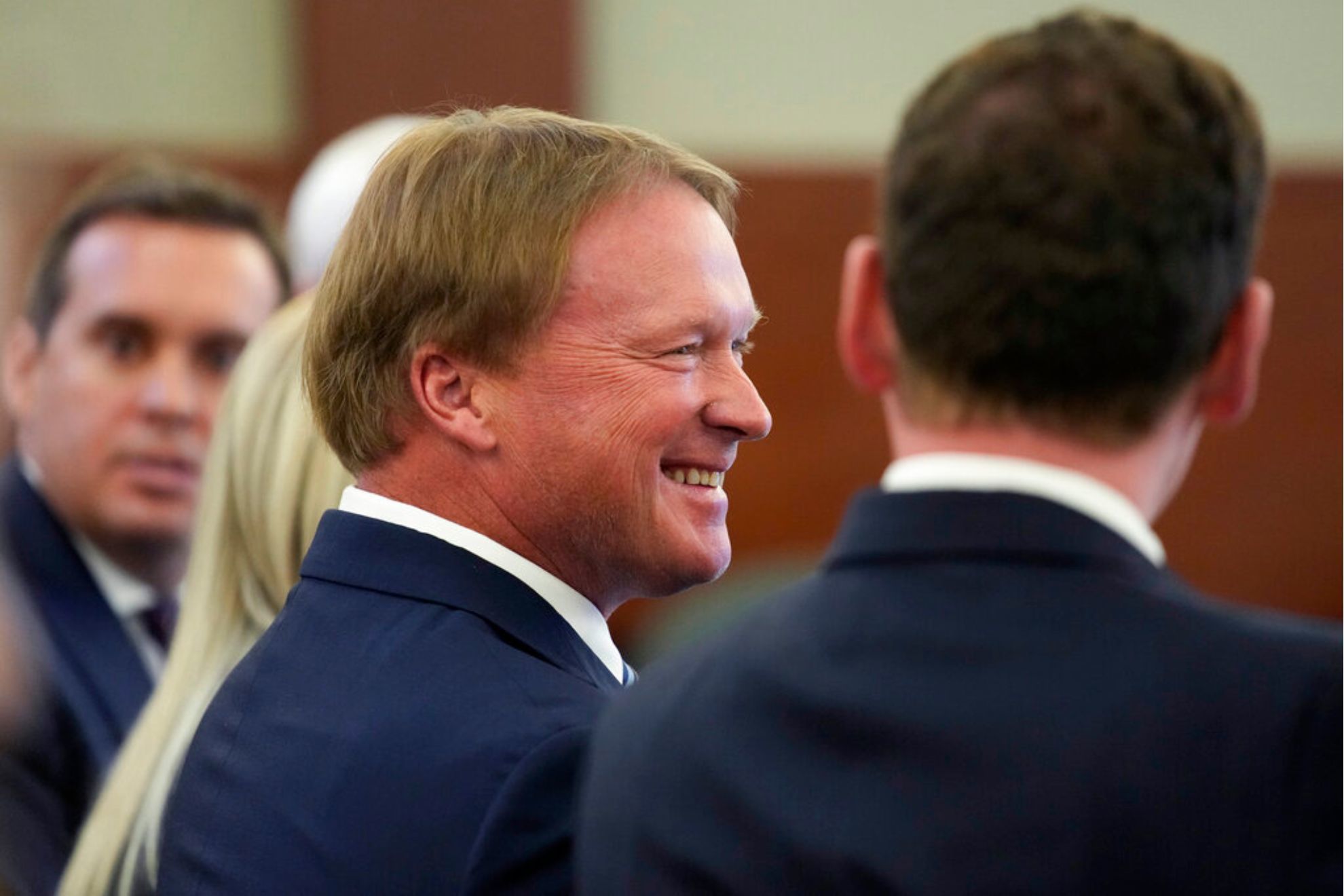 Jon Gruden smiles in court Wednesday, May 25, 2022, in Las Vegas