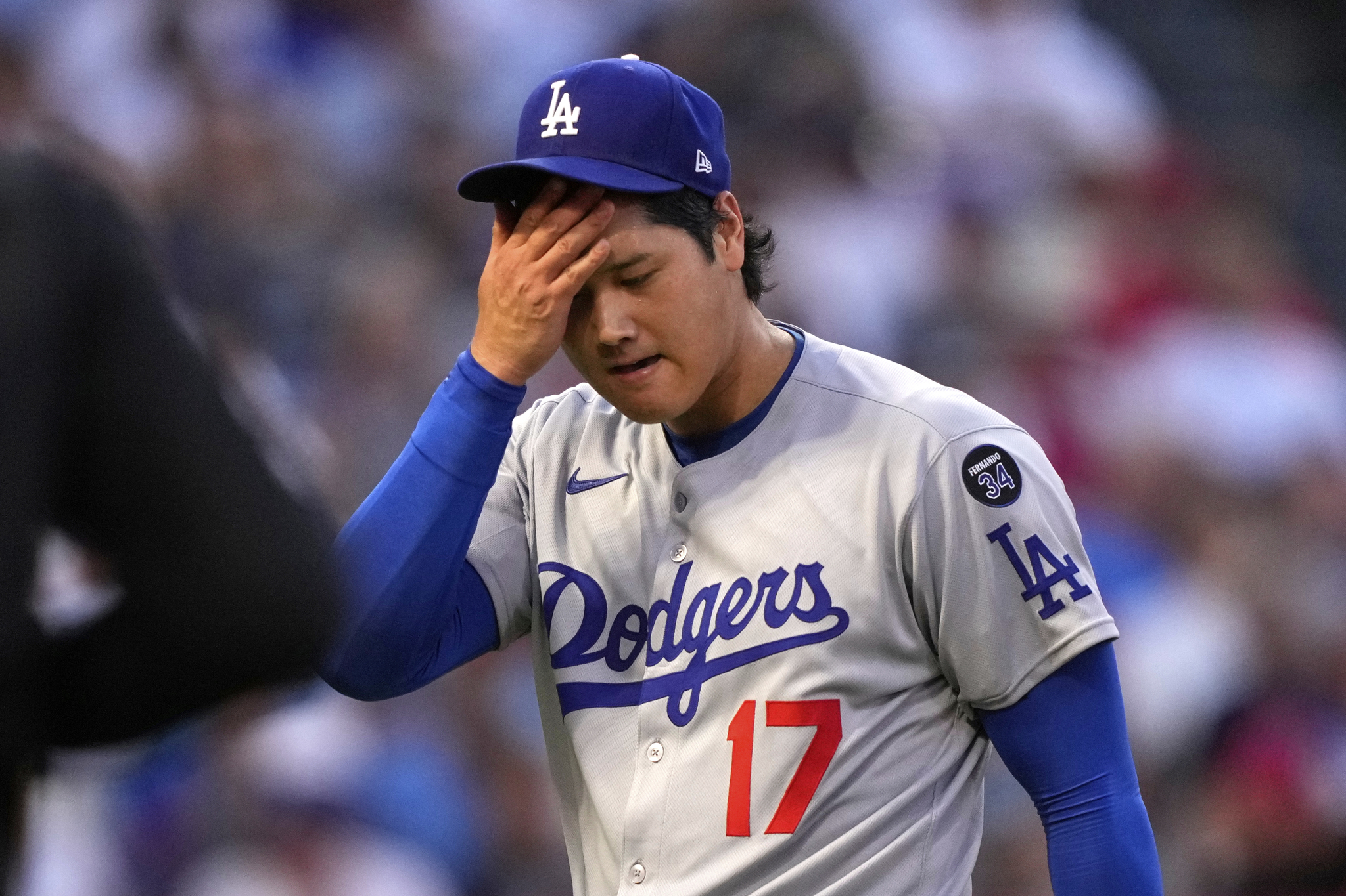 Los Angeles Dodgers starting pitcher Shohei Ohtani wipes his face after the third inning during of a baseball game against the Los Angeles Angels, Wednesday, Aug. 13, 2025, in Anaheim, Calif. (AP Photo/Mark J. Terrill)