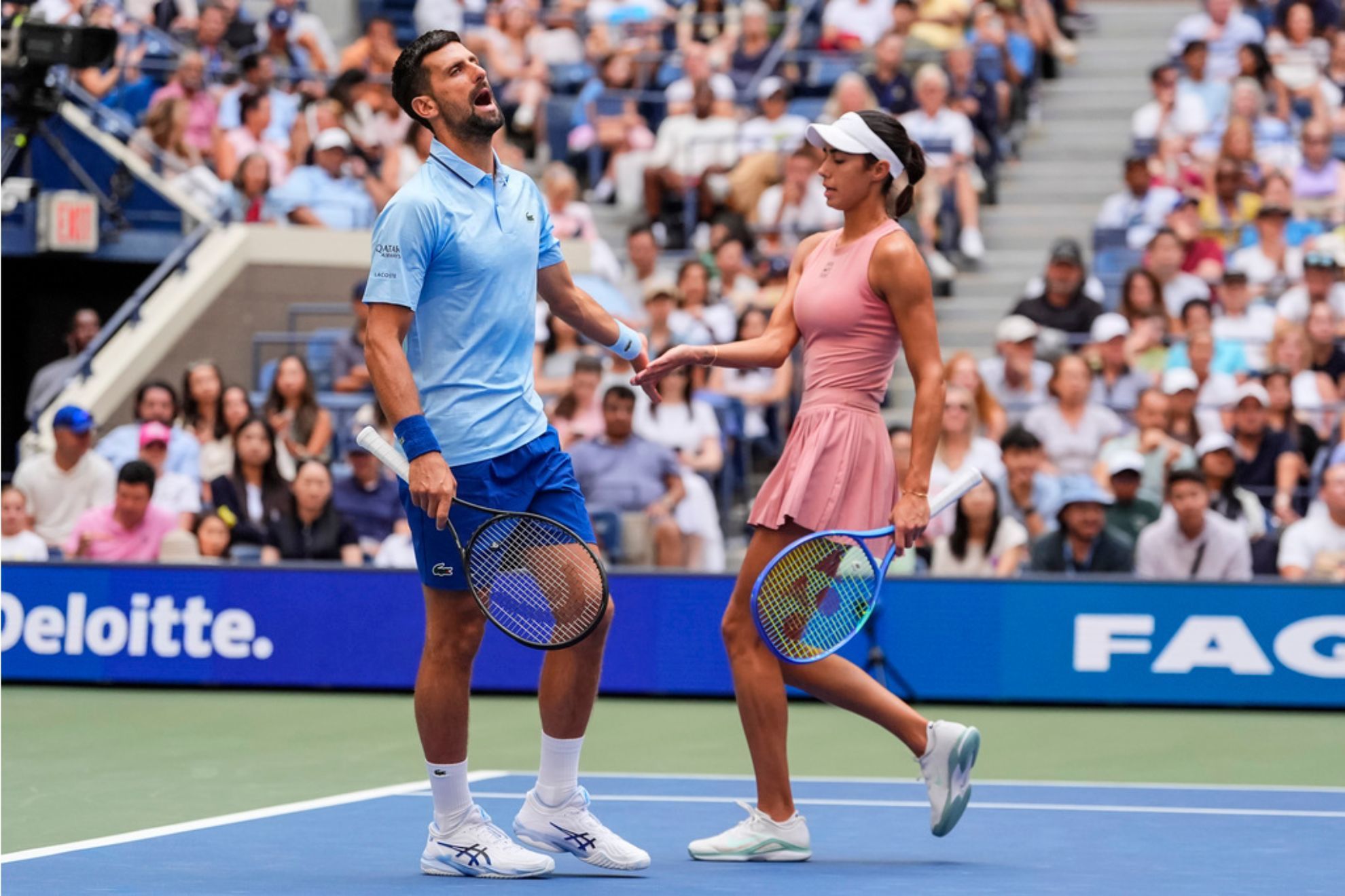 Novak Djokovic, left, of Serbia, and Olga Danilovic, right, of Serbia, interact during their mixed doubles match at the U.S. Open