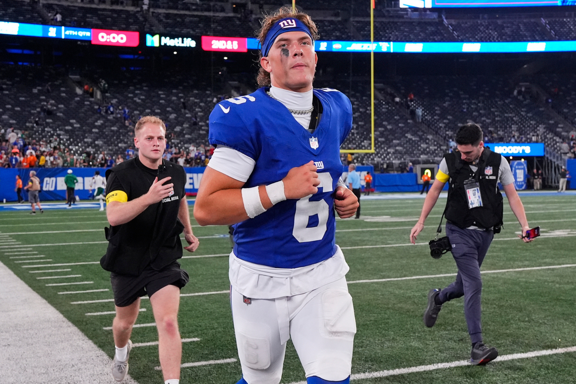 New York Giants quarterback Jaxson Dart runs onto the field during a preseason game.