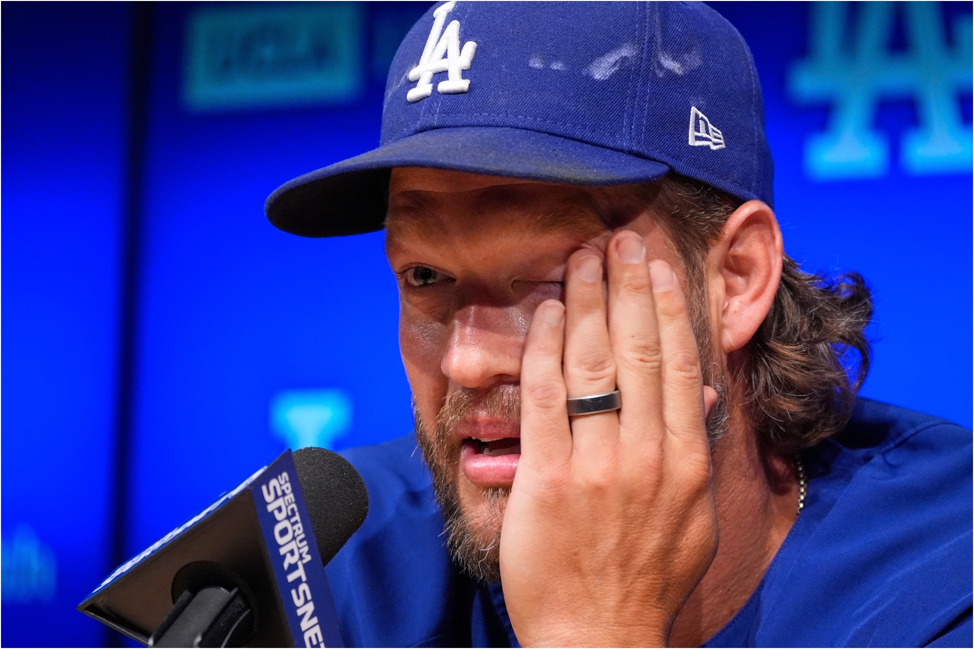 Los Angeles Dodgers pitcher Clayton Kershaw wipes his eyes as he speaks.